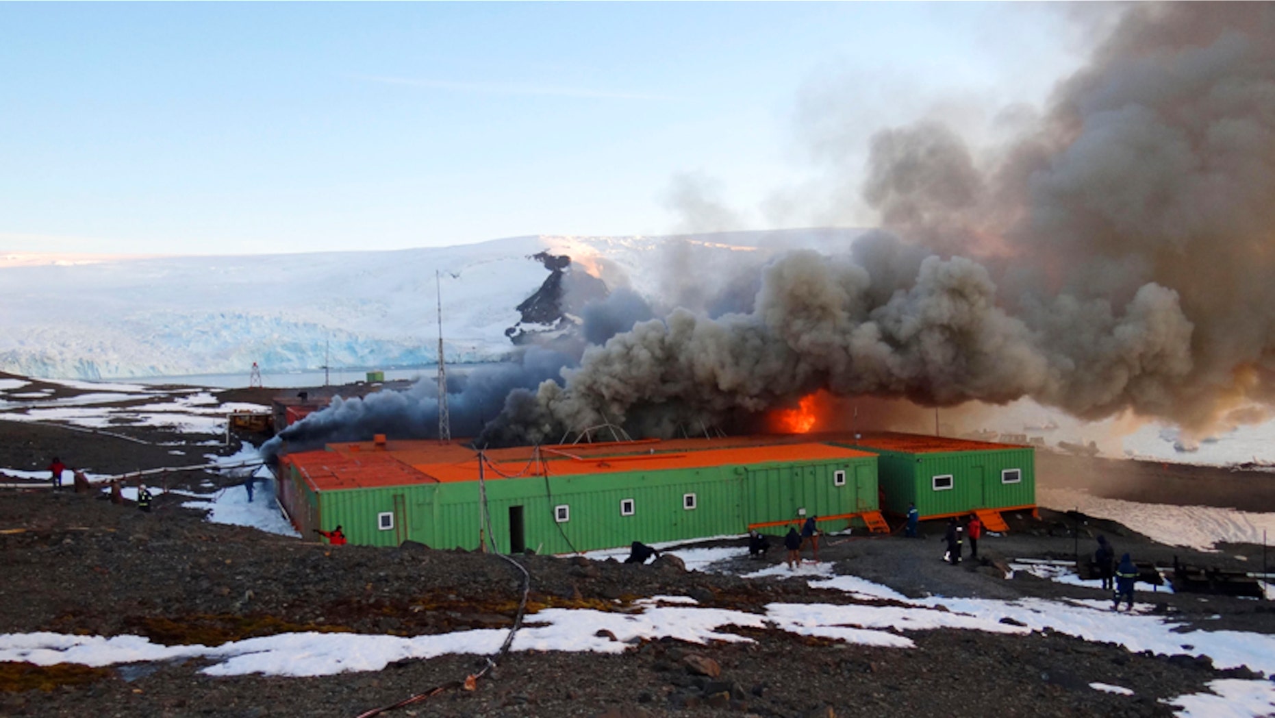 In this photo released by Armada de Chile, fire and smoke rise from Brazil's Comandante Ferraz station in Almirantazgo Bay, in the South Shetland Islands of Antarctica, Saturday Feb. 25, 2012. In an emailed statement, the Brazilian navy said the fire broke out Saturday morning in the machine room that houses the energy generators of the station where one man suffered non-life threatening injuries, and at least two people were reported missing. (AP Photo/Armada de Chile)