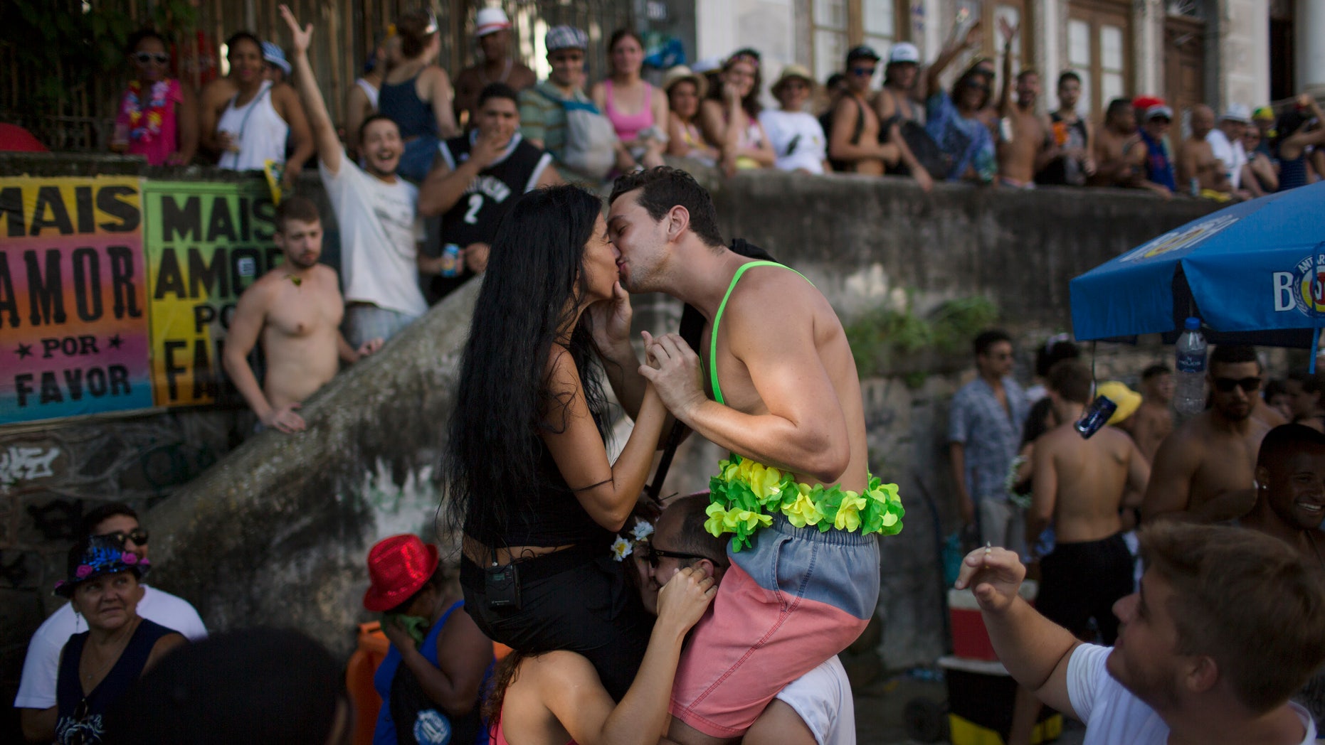 A couple kisses during the "Carmelitas" block party, during Carnival celebrations in Rio de Janeiro, Brazil, Friday, Feb. 5, 2016. Top Brazilian Health officials said this Friday that the active Zika virus has been found in urine and saliva samples, cautioning that further study is needed to determine whether the mosquito-borne virus in those body fluids is capable of infecting people. (AP Photo/Leo Correa)