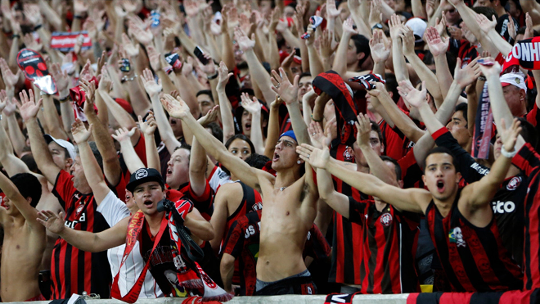 FILE - In this Nov.27, 2013 file photo, Atletico Paranaense fans cheer for their team during the Copa do Brazil final match against Flamengo in Rio de Janeiro, Brazil. Brazilians fans idolize their stars on the fields, courts and tracks. They'll cheer loudly at any sporting event they'll go to, be it a World Cup match, a Formula One race or a mixed martial arts fight. (AP Photo/Victor R. Caivano, File)