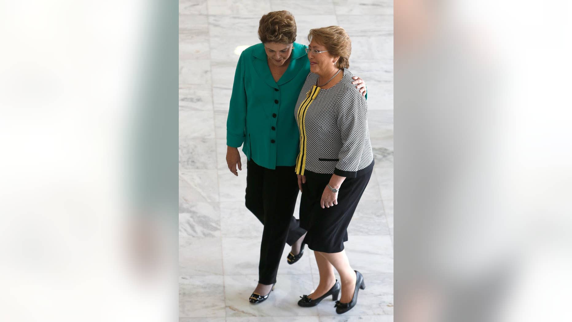 FILE - In this June 12, 2014 file photo, Brazil's President Dilma Rousseff, left, welcomes Chile's President Michelle Bachelet at Planalto presidential palace in Brasilia, Brazil. The once-popular presidents have both seen their approval ratings plunge amid corruption scandals that have battered their center-left governments, according to two polls released Wednesday, April 1, 2015. (AP Photo/Eraldo Peres, File)