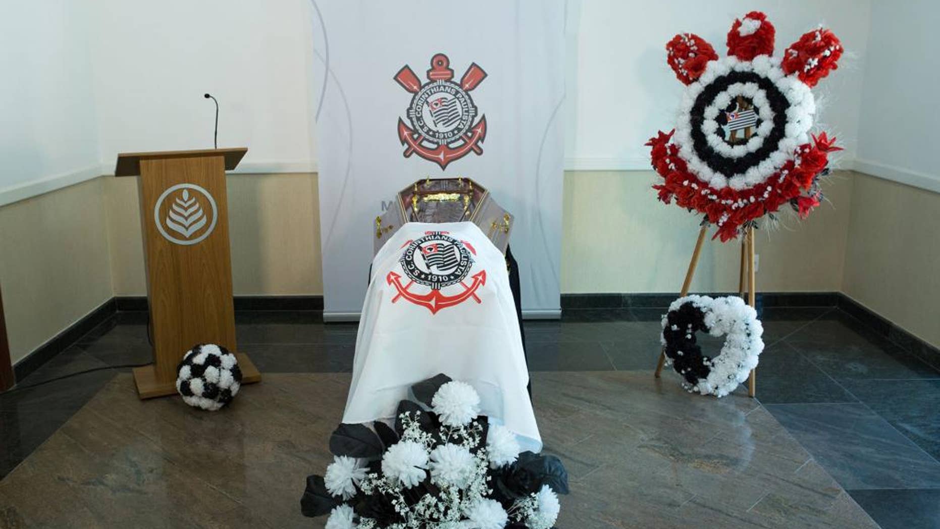 This undated photo released by the Corinthians soccer team shows an empty casket draped with the team's flag in Sao Paulo, Brazil. Corinthians says it’s building its own cemetery, complete with a mock football field and VIP tribunes where some of the team’s greatest players will be offered burial spaces. The “Corinthians Forever” cemetery is expected to open late in 2015, but fans can already start booking one of the 70,000 burial places available. (AP Photo/Ivo Duran, Corinthians)