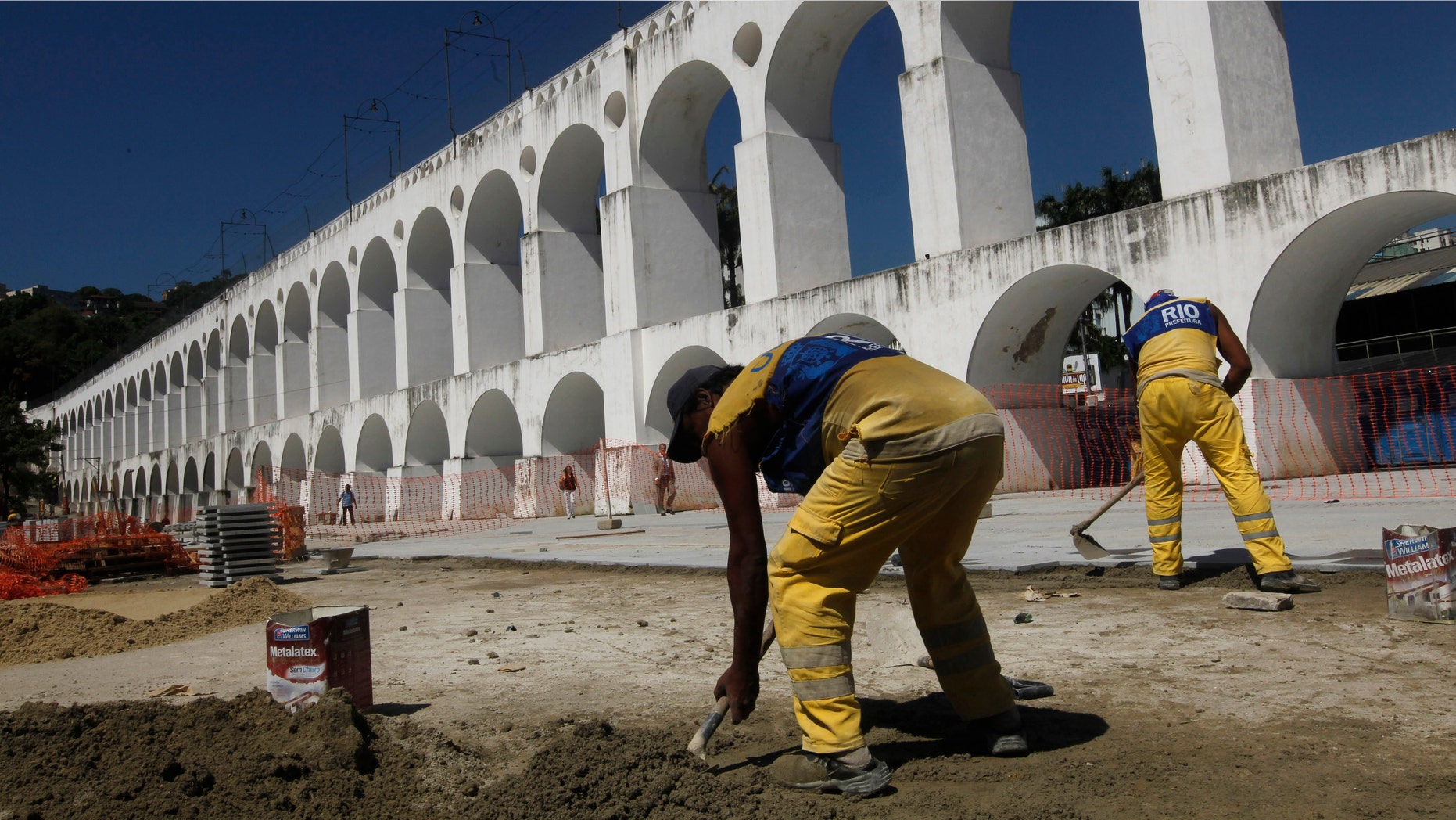 Workers repave the plaza in front of Rio de Janeiro's "Arcos da Lapa," an aqueduct converted into a trolley bridge, on Feb. 1. In the past year, a trolley car ran off the arches' rails, killing five. These accidents are contributing to a growing concern about Rio de Janeiro's readiness to host the finals of the 2014 World Cup as well as the 2016 Olympics. (AP Photo/Silvia Izquierdo)
