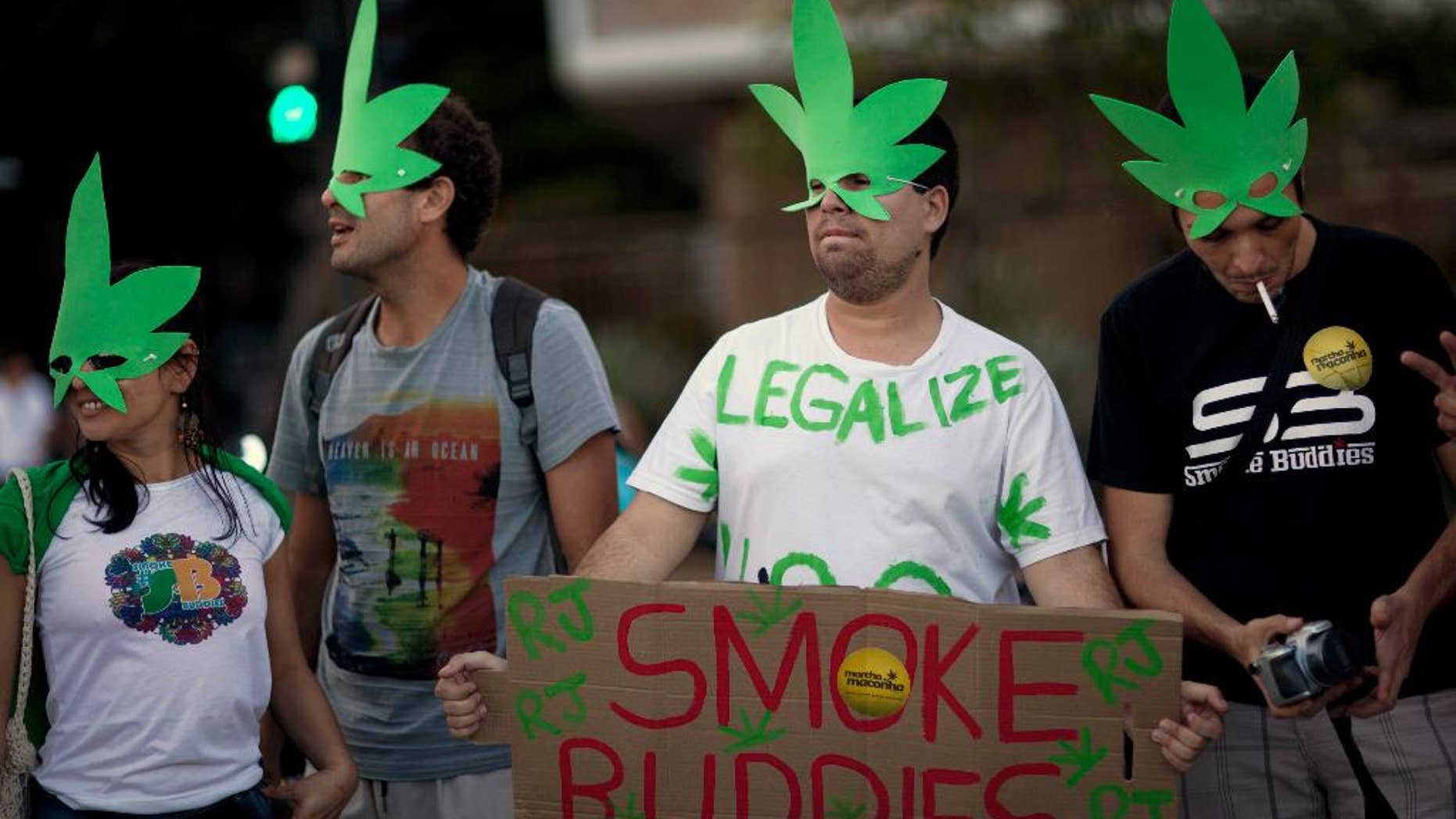 FILE - In this May 11, 2013 file photo, demonstrators wear cannabis shaped masks to support the legalization of marijuana in Rio de Janeiro, Brazil, during a march marking the 32 anniversary of Jamaican musician Bob Marley's death. Brazil's Supreme Court on Wednesday, Aug. 19, 2015 began debating a drug case that could lead to the decriminalization of drug possession for personal use. A final ruling is not expected for several days. (AP Photo/Felipe Dana, File)