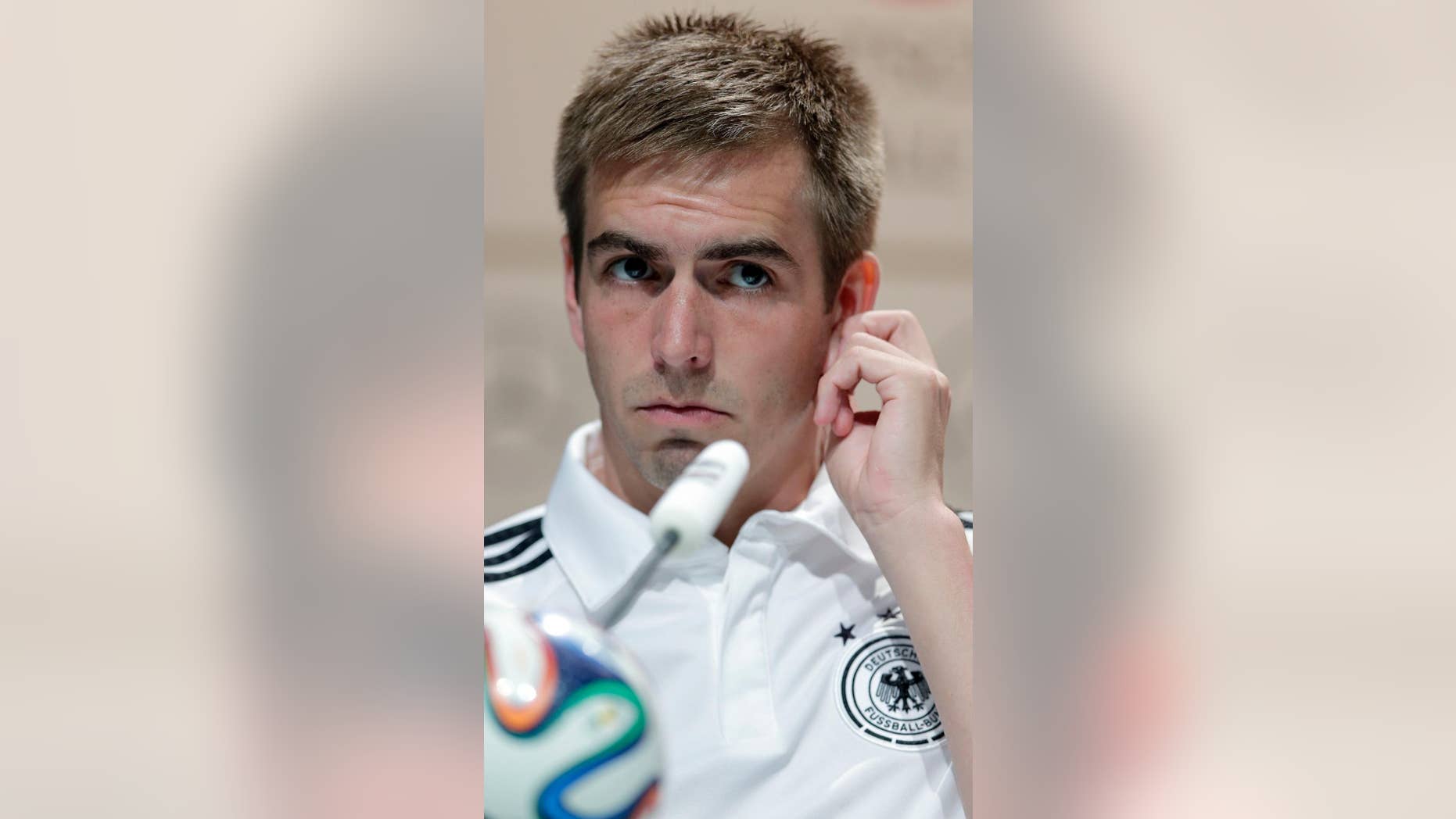 Germany's national soccer team captain Philipp Lahm listens to reporters' questions during a news conference in Porto Seguro, Brazil, Tuesday, June 10, 2014. Germany will play in group G of the Brazil 2014 soccer World Cup. (AP Photo/Matthias Schrader)