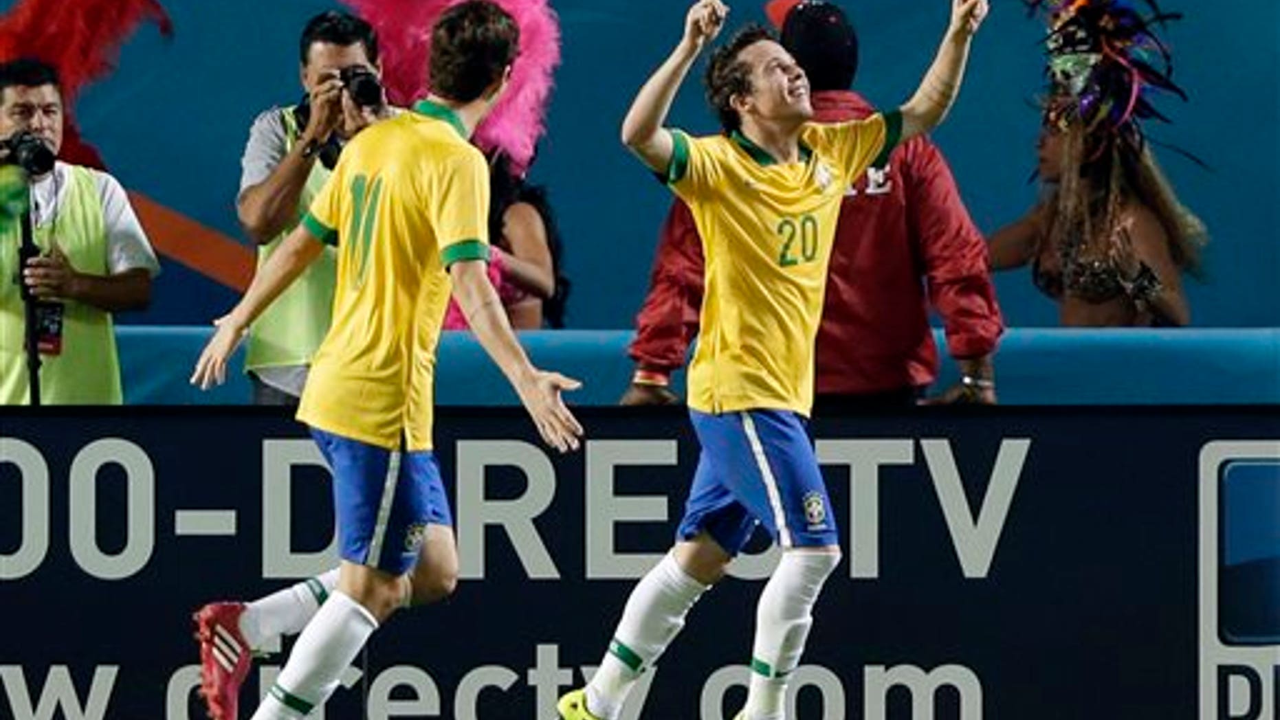 Brazil forward Bernard (20) celebrates his goal with midfielder Oscar (11) during the first half of an international friendly soccer game against Honduras, Saturday, Nov. 16, 2013, in Miami Gardens, Fla. (AP Photo/Wilfredo Lee)
