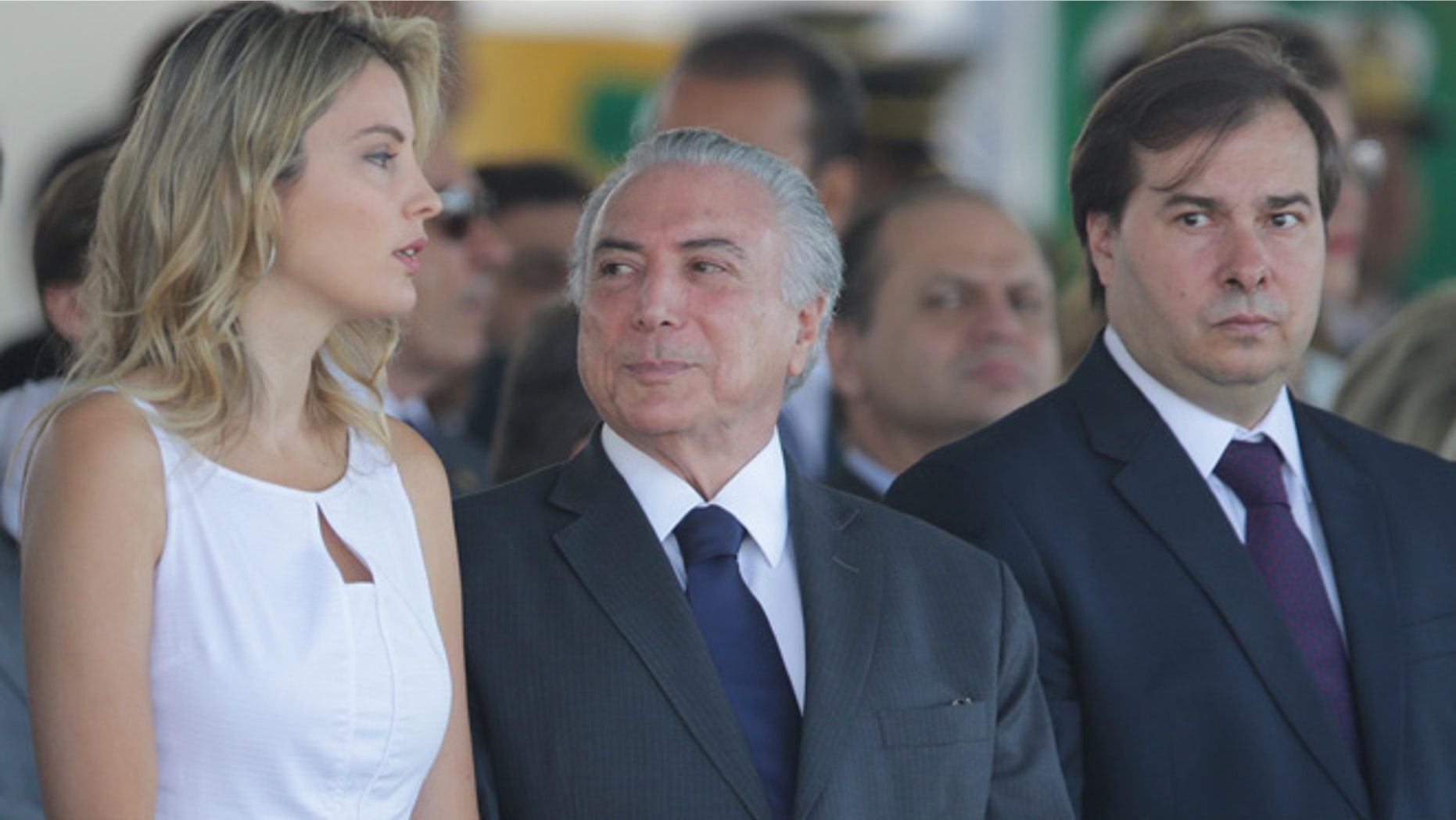 Brazil's President Michel Temer, center, talks with his wife Marcela Temer, during an Independence Day military parade in Brasilia, Brazil, Wednesday, Sept. 7, 2016. Pictured right is Lower House Speaker Rodrigo Maia. (AP Photo/Eraldo Peres)