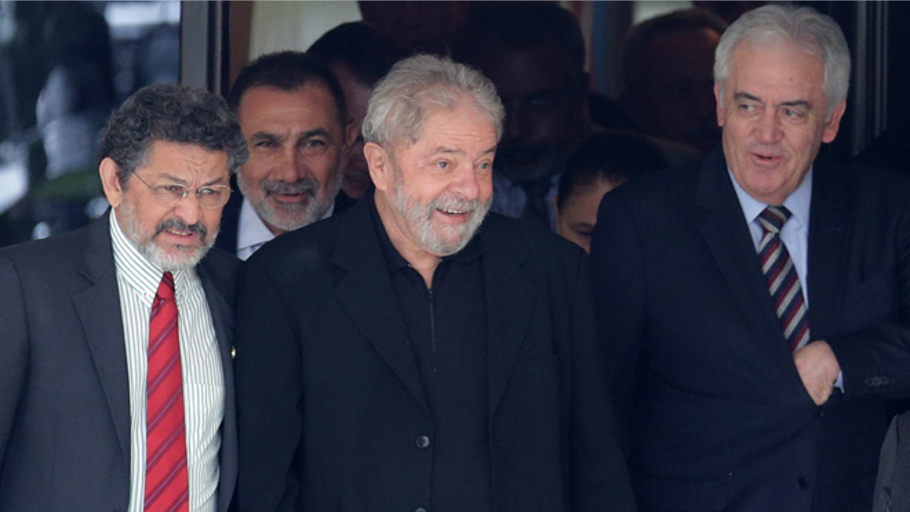 Brazilâs former President Luiz Inacio Lula da Silva, center, smiles as he leaves a breakfast with senators of the government's allied base, in Brasilia, Brazil, Wednesday, March 9, 2016. (AP Photo/Eraldo Peres)