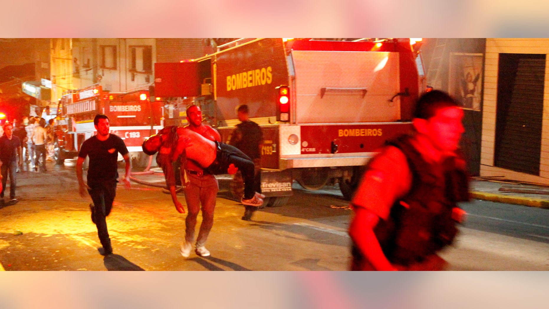 A man carries an injured man, victim of a fire at the Kiss club in Santa Maria city, Rio Grande do Sul state, Brazil, early Sunday, Jan. 27, 2013. (AP Photo/Agencia RBS)