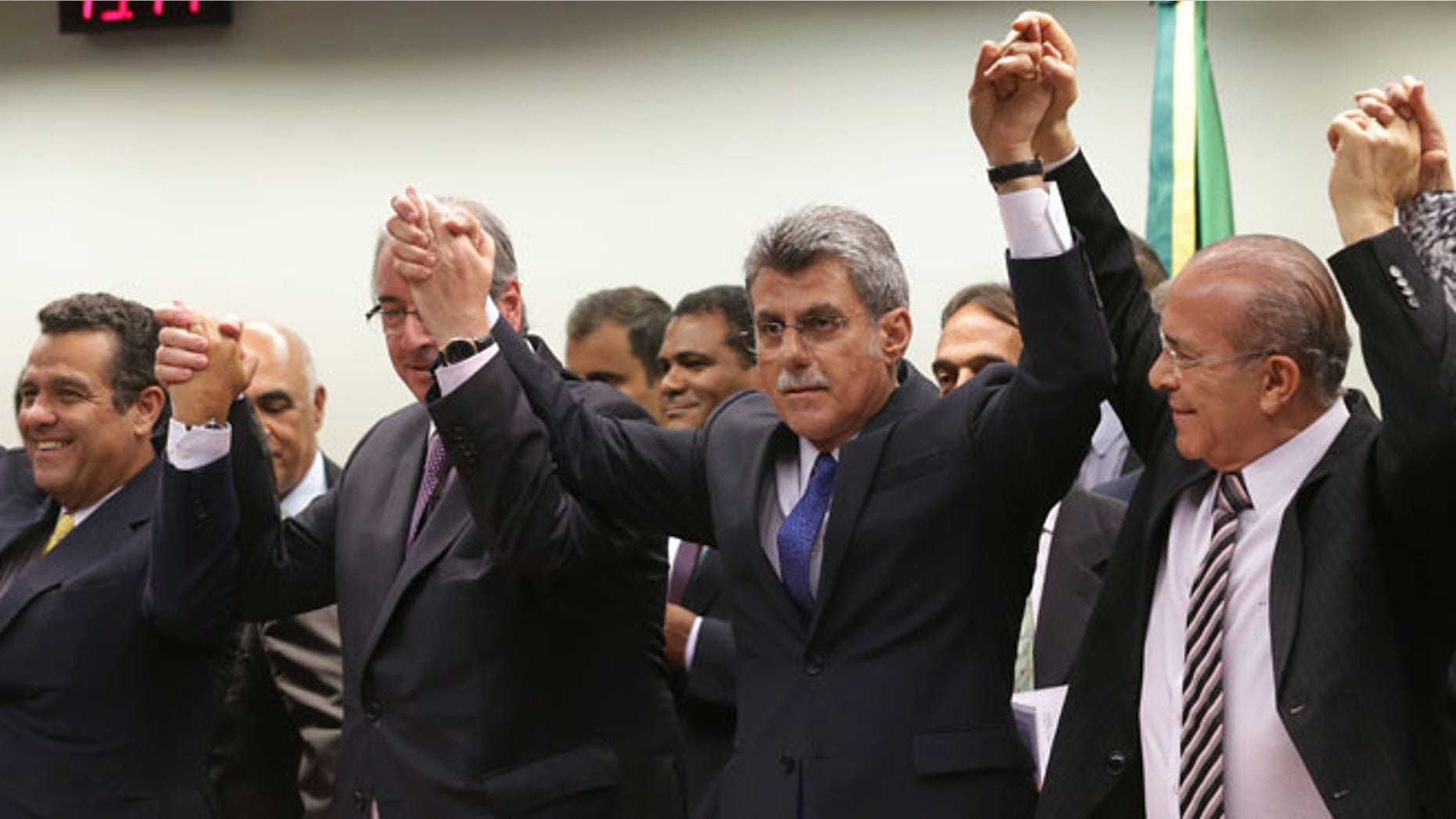 The speaker of Brazil's lower house of Congress Eduardo Cunha, from second front left, Romero Juca, vice president of Brazil's largest party, the Democratic Movement Party (PMDB), and Eliseu Padilha, a former transportation minister, celebrate their decision to abandon President Dilma Rousseff's governing coalition, at the National Congress, in Brasilia, Brazil, Tuesday, March 29, 2016.