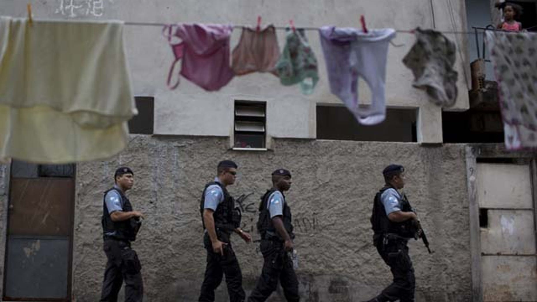 July 21, 2013: Policemen from the Pacifying Police Unit, or 'UPP', patrol in the Varginha area of the Manguinhos slum complex where Pope Francis will visit next week during his trip to Rio de Janeiro, Brazil (AP Photo)