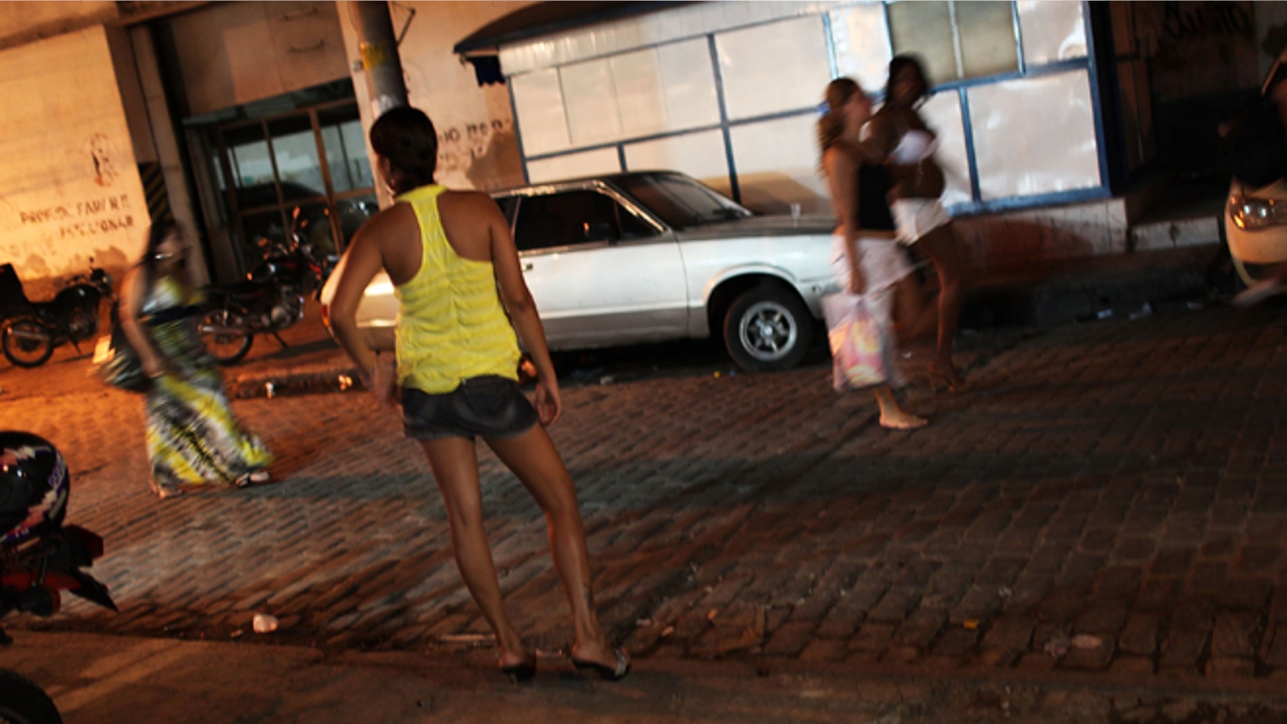 RIO DE JANEIRO, BRAZIL - DECEMBER 11: Female prostitutes walk the streets of the red light district, Vila Mimosa, following a fashion show with clothes designed by sex workers on December 11, 2009 in Rio de Janeiro, Brazil. The fashion show, which is a government sponsored project to give female prostitutes other career choices, displayed dozens of new designs on both models and three fellow prostitutes. The Association of the Residents and Friends of Vila Mimosa teaches the women skills in sewing and design. Out of the 105 woman to enroll in the fashion design program 65 have now found jobs in other professions besides working in the sex industry. (Photo by Spencer Platt/Getty Images)