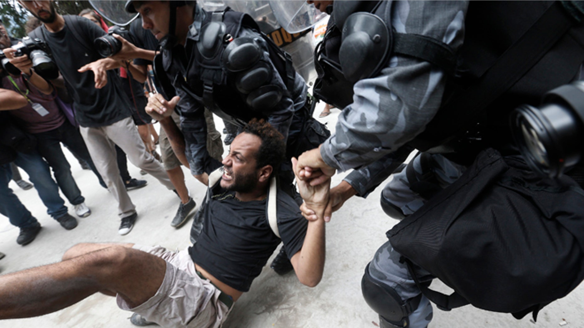 A man is carried away during a protest next to the Maracana Stadium in Rio de Janeiro, on Dec. 16, 2013.