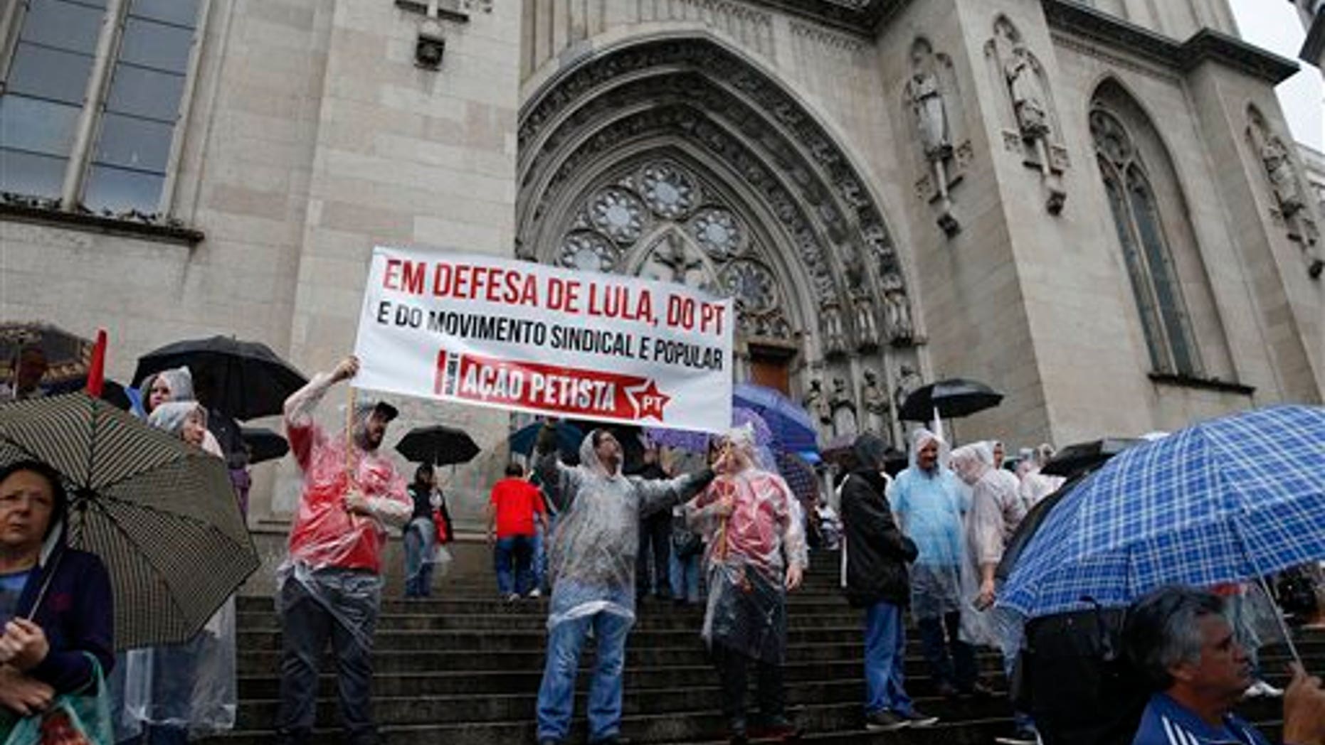 Demonstrators gather on the cathedral steps to show support for former Brazil's President Luiz Inacio Lula da Silva, in Sao Paulo, Brazil, Friday, March 11, 2016. Sao Paulo state prosecutors said Thursday they filed money laundering and criminal misrepresentation charges against the former leader because of evidence he and his family unduly benefited from a real estate scheme that adversely affected thousands of Brazilian families. (AP Photo/Andre Penner)