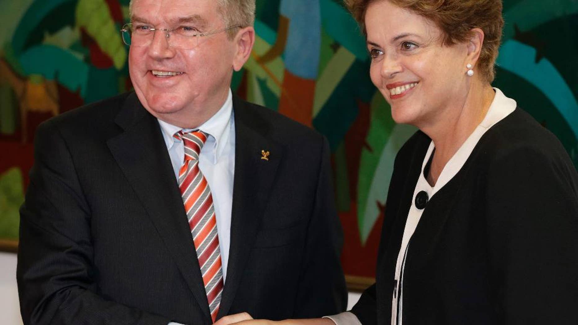 Brazil’s President Dilma Rousseff, right, shakes hands with International Olympic Committee President Thomas Bach at the Planalto presidential palace in Brasilia, Brazil, Tuesday, Feb. 24, 2015. The IOC's coordination commission is visiting venues and meeting with local organizers as Rio races to be ready on time for South America's first games, set for 2016. (AP Photo/Eraldo Peres)