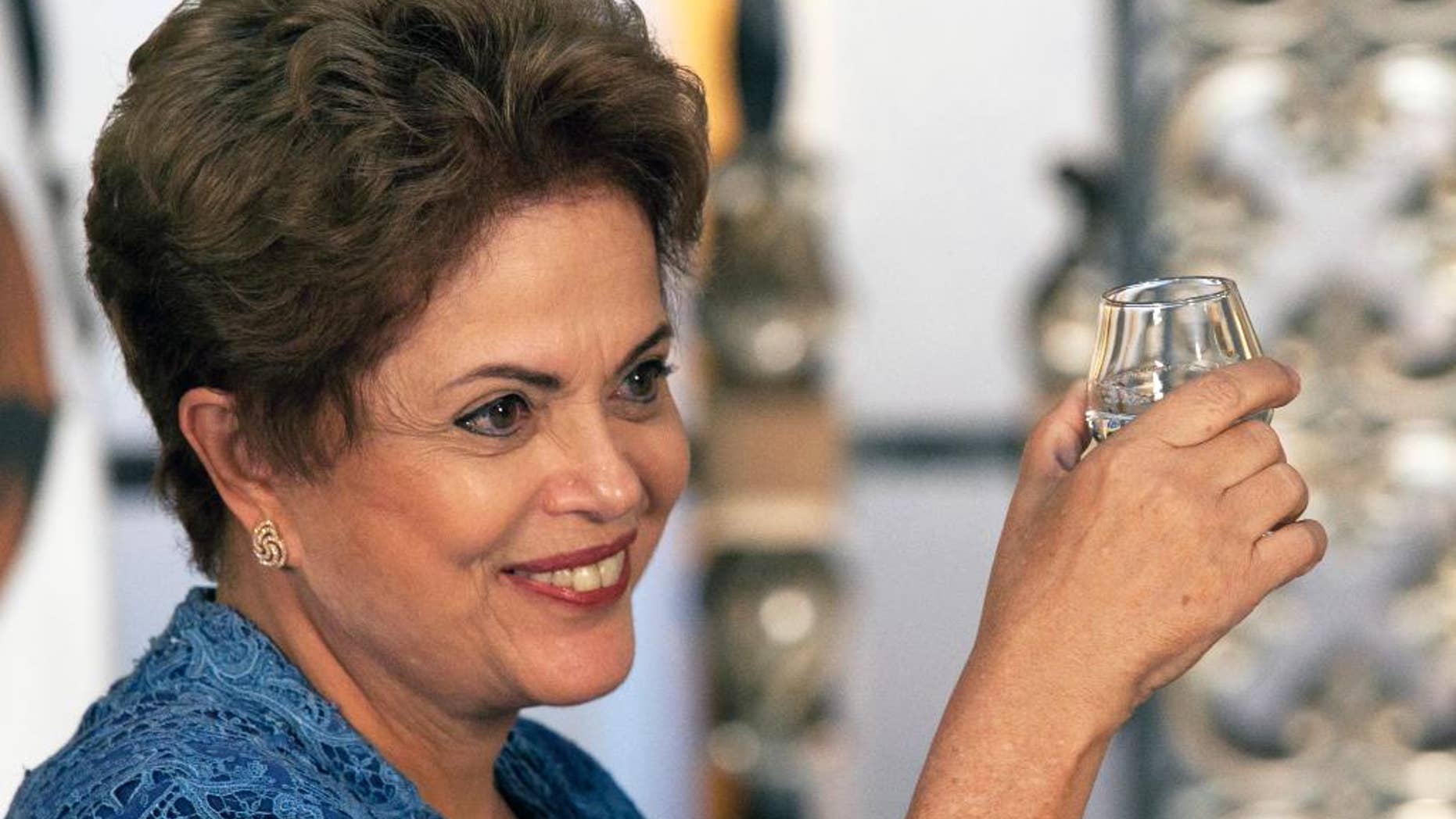 FILE - In this May 26, 2015, file photo, Brazil's President Dilma Rousseff raises her cup during a toast with Mexico's President Enrique Pena Nieto, not in photo, during an official ceremony at the National Palace in Mexico City. Rousseff's popularity ratings have dropped to levels not seen since the government of disgraced former president Fernando Collor de Mello in 1992, according to a poll published Sunday, June 21. (AP Photo/Marco Ugarte, File)