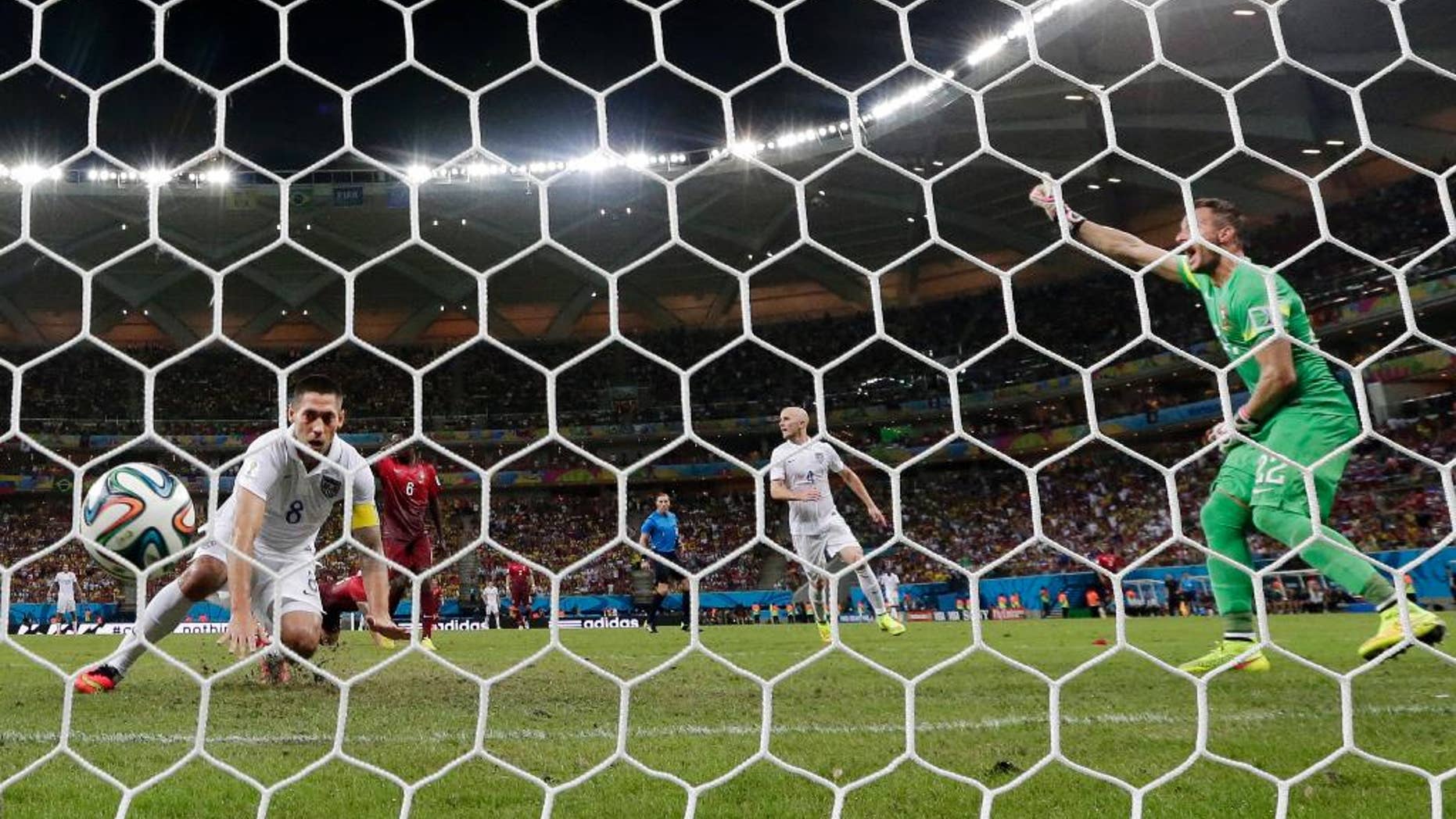 United States' Clint Dempsey, left, scores his side's second goal during the group G World Cup soccer match between the USA and Portugal at the Arena da Amazonia in Manaus, Brazil, Sunday, June 22, 2014. (AP Photo/Julio Cortez)