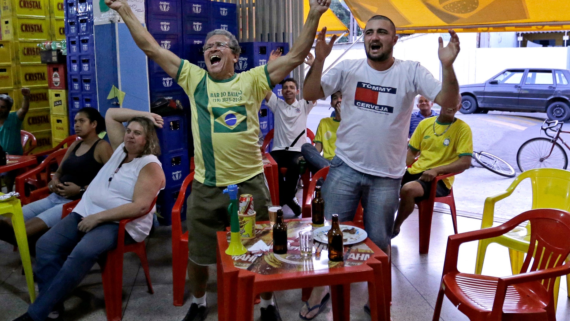 Brazil supporters cheer as they watch on the television the group A World Cup soccer match between Brazil and Mexico, at a bar in Indaiatuba, Brazil, Tuesday, June 17, 2014.(AP Photo/Shuji Kajiyama)