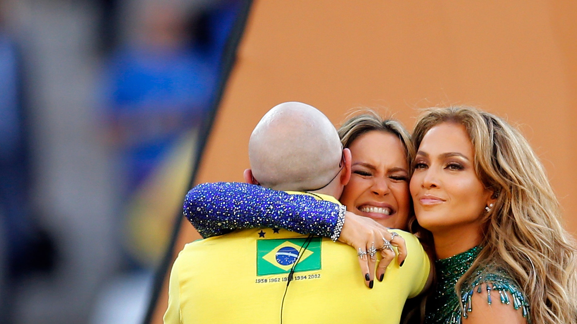 Brazilian singer Claudia Leitte embraces Jennifer Lopez and Pitbull in the Itaquerao Stadium in Sao Paulo, June 12, 2014.