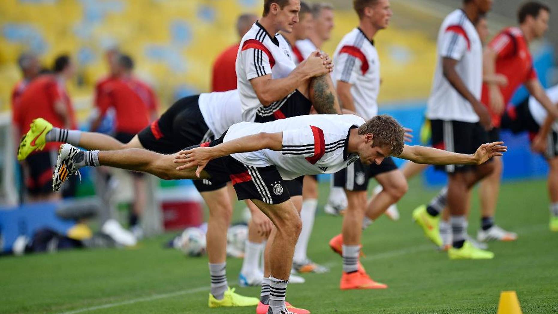 Germany's Thomas Mueller, in front, and Germany's Miroslav Klose, behind him, exercise during an official training session one day before the World Cup quarterfinal soccer match between Germany and France at the Maracana Stadium in Rio de Janeiro, Brazil, Thursday, July 3, 2014. (AP Photo/Martin Meissner)