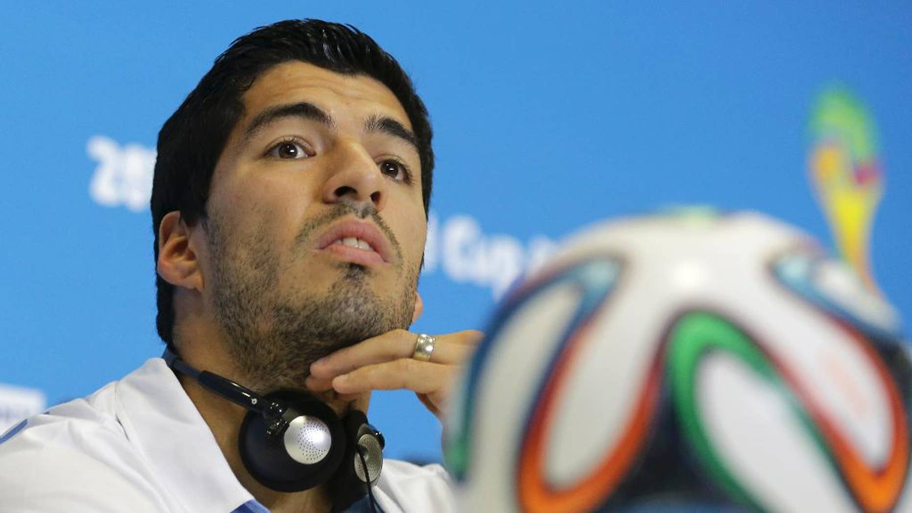 FILE - In this June 23, 2014 file photo, Uruguay's Luis Suarez listens to a question during a press conference at the Arena das Dunas in Natal, Brazil. Suarez was banned for nine competitive international matches, four months from all football and fined for biting Italy's Giorgio Chiellini's shoulder during their group D World Cup soccer match. Football's international governing body on Thursday, July 10, 2014, said its appeals committee rejected Suarez's appeal against his ban for biting his opponent. (AP Photo/Antonio Clanni, File)