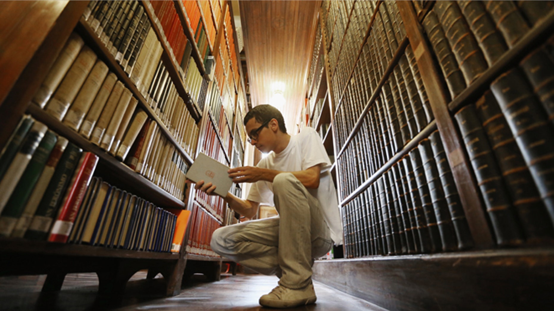 SAO PAULO, BRAZIL - MARCH 12: Philosphy student Sergio Araujo sorts books in a 19th-century library inside Sao Bento Monastery on March 12, 2013 in Sao Paulo, Brazil. The monastery is said to be the oldest institution in Sao Paulo; Benedictines arrived at the site in 1598. Pope Benedict XVI visited Sao Bento in 2007. Brazil has more Catholics than any other country in the world and supporters hope Sao Paulo Archbishop Cardinal Odilo Pedro Scherer will be chosen as the next Pope during the papal conclave. (Photo by Mario Tama/Getty Images)