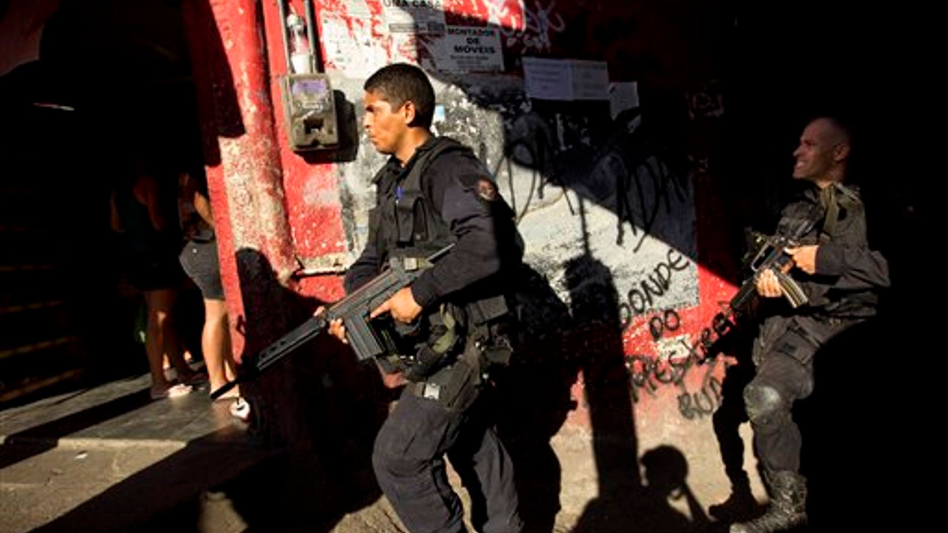 April 4, 2012: Police officers belonging to the BOPE (Special Police Operations Battalion) unit, patrol the Rocinha slum in Rio de Janeiro, Brazil.