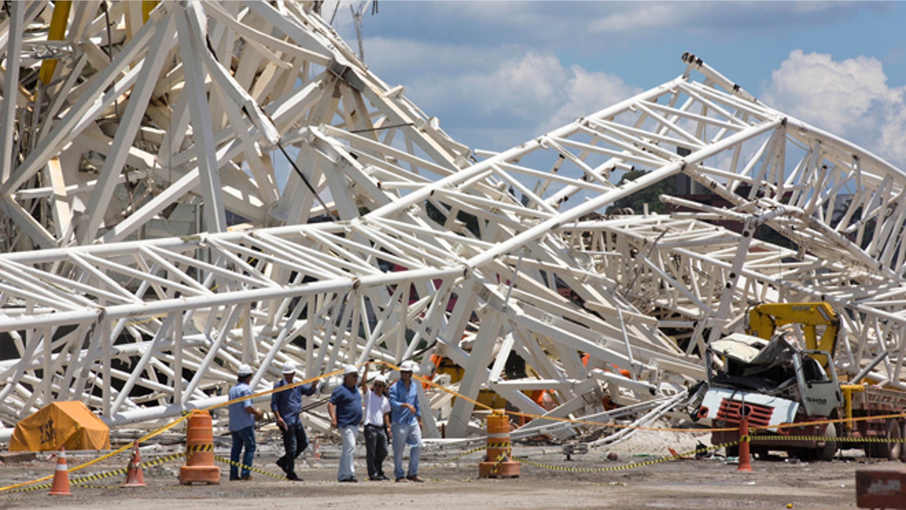 Civil defense and policemen inspect the damage of an accident at the Arena Corinthians, known locally as the Itaquerao, that will host the 2014 World Cup in Sao Paulo, Brazil, Thursday, Nov. 28, 2013. Two workers were killed when a crane crashed into a 500-ton metal structure that toppled over part of the stadium Wednesday, aggravating already urgent worries that Brazil won't be ready for soccer's showcase event next year. (AP Photo/Andre Penner)