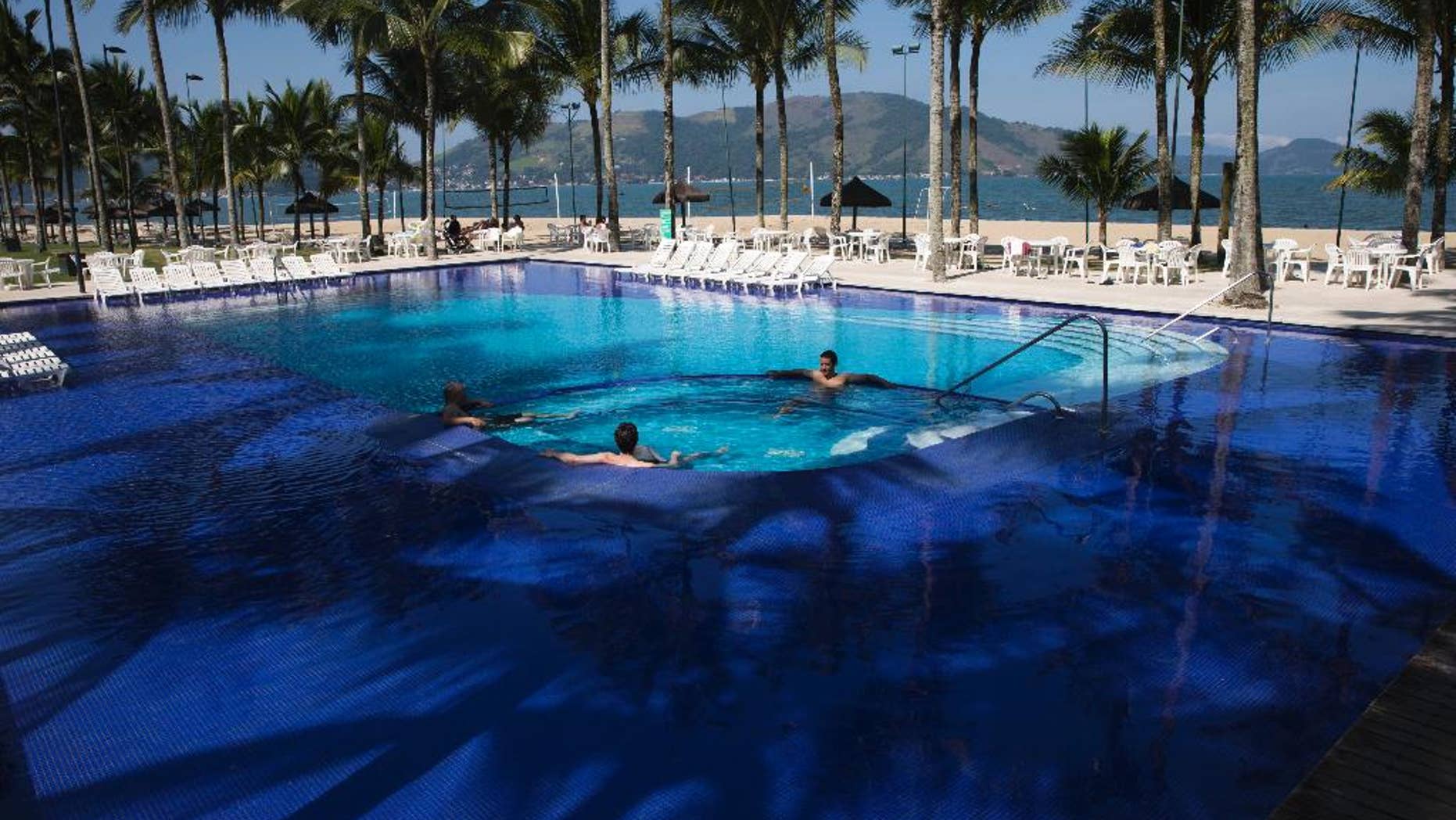 FILE - In this May 8, 2014 file photo, guests wade in the pool at Hotel Portobello where Italy's soccer team will train and reside during the World Cup in Mangaratiba, Brazil. A Brazilian consumer defense agency said Monday, May 26, 2014 it's found past-expiration food at Hotel Portobello as well as the Royal Tulip Hotel where England's team will stay during the World Cup. The Rio de Janeiro state agency said that the inspections were part of an effort to enforce food safety codes ahead of next month's tournament. (AP Photo/Hassan Ammar, File)