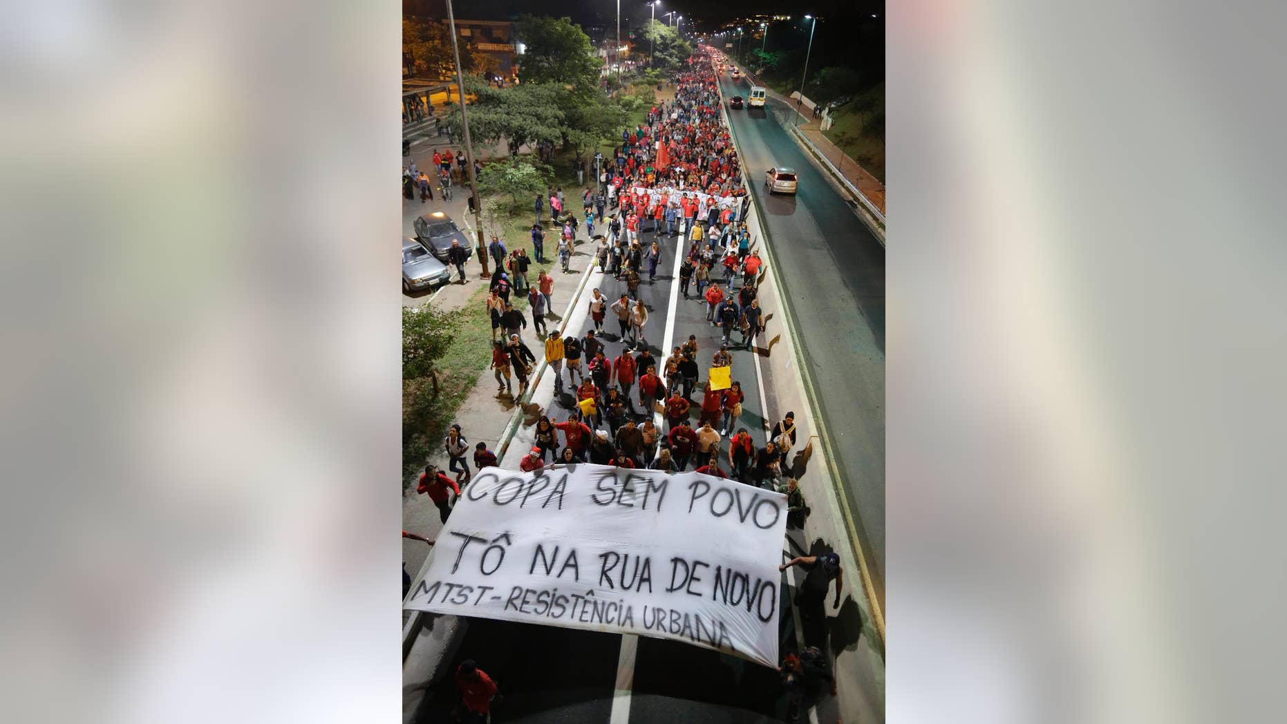 Members of the Homeless Workers Movement holding a banner that reads in Portuguese "World Cup without the People, then I am in the street again", march during a protest demanding better public services and against the money spent on the World Cup preparations in Sao Paulo, Brazil, Wednesday, June 4, 2014. (AP Photo/Nelson Antoine)