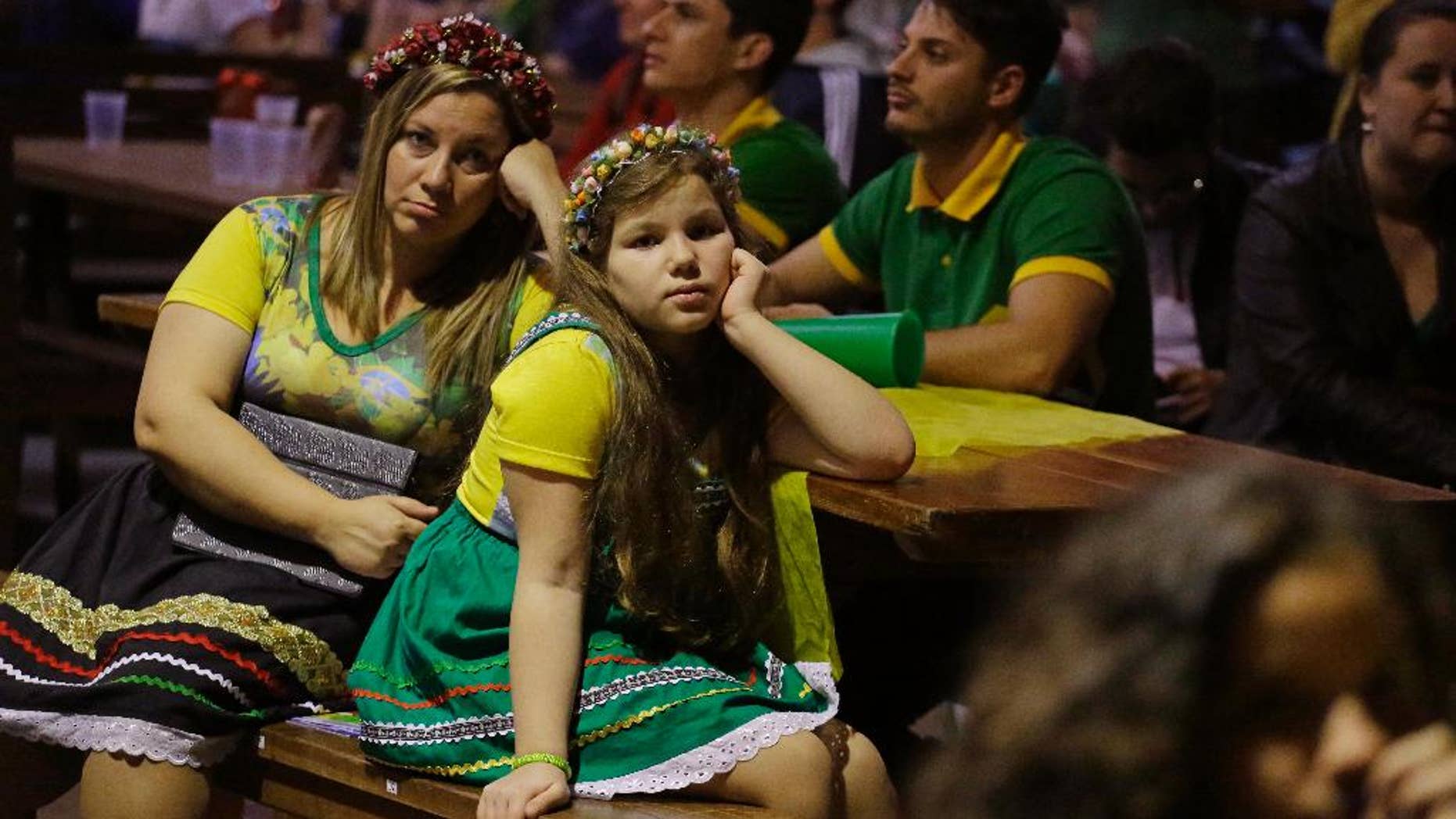 Brazilians of German descent watch Brazil lose 7-1 to Germany at a World Cup semifinal match on TV in Blumenau, Brazil, Tuesday, July 8, 2014. The German community in southern Brazil organized an Oktoberfest party to watch the Brazil vs. Germany match. (AP Photo/Nelson Antoine)