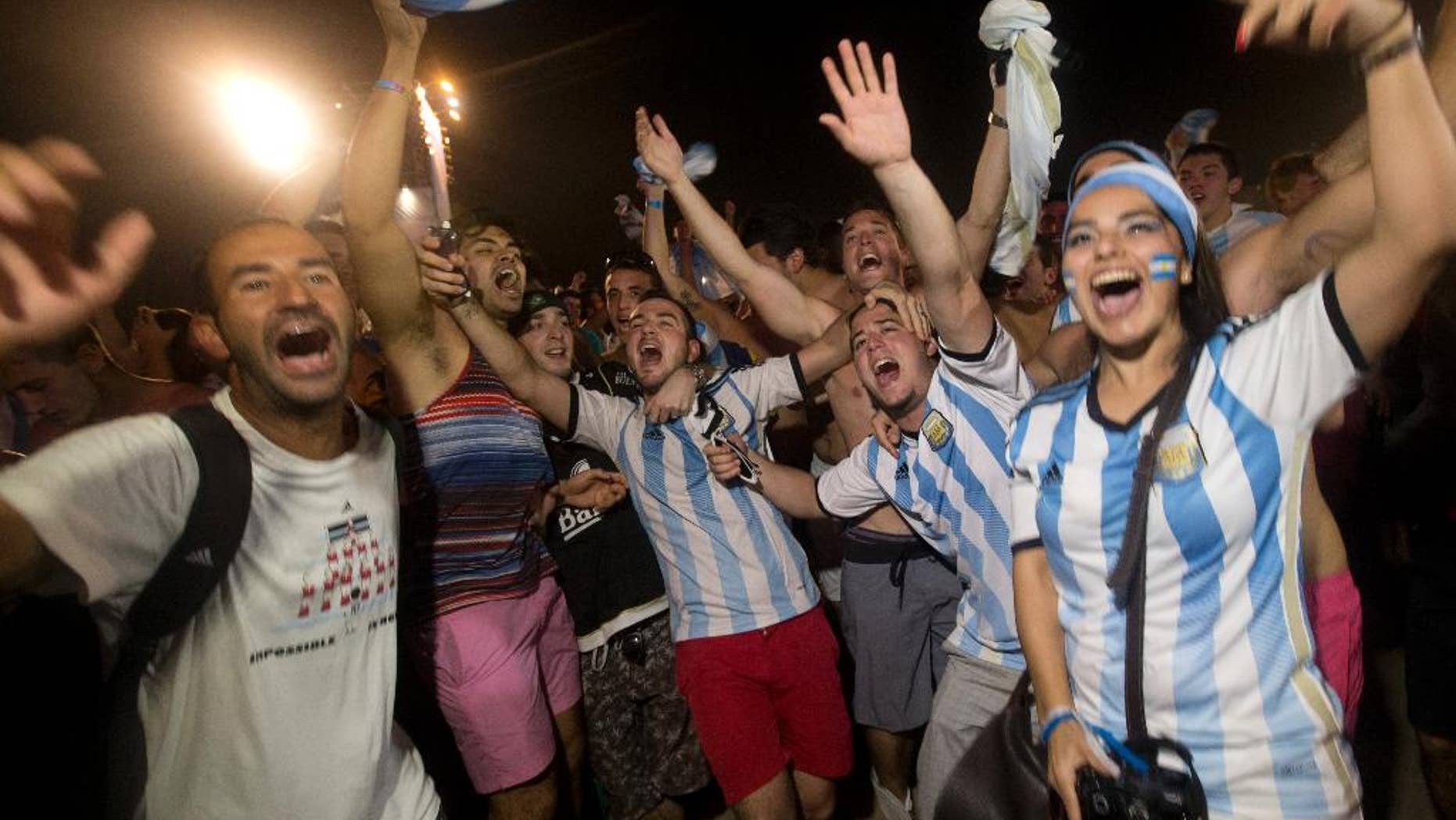 Soccer fans of the Argentina national soccer team celebrate their team's victory during a live broadcast of the soccer World Cup match between Argentina and the Netherlands, inside the FIFA Fan Fest area on Copacabana beach, in Rio de Janeiro, Brazil, Wednesday, July 9, 2014. Argentina made it to the World Cup final with a 4-2 shootout win over the Netherlands after the game finished in a 0-0 stalemate. (AP Photo/Silvia Izquierdo)
