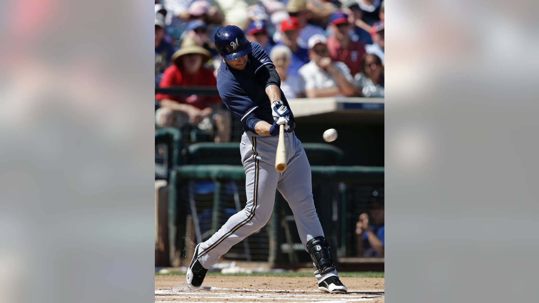Milwaukee Brewers' Ryan Braun hits an RBI double during the first inning of a spring exhibition baseball game against the Texas Rangers Friday, March 21, 2014, in Surprise, Ariz. (AP Photo/Darron Cummings)