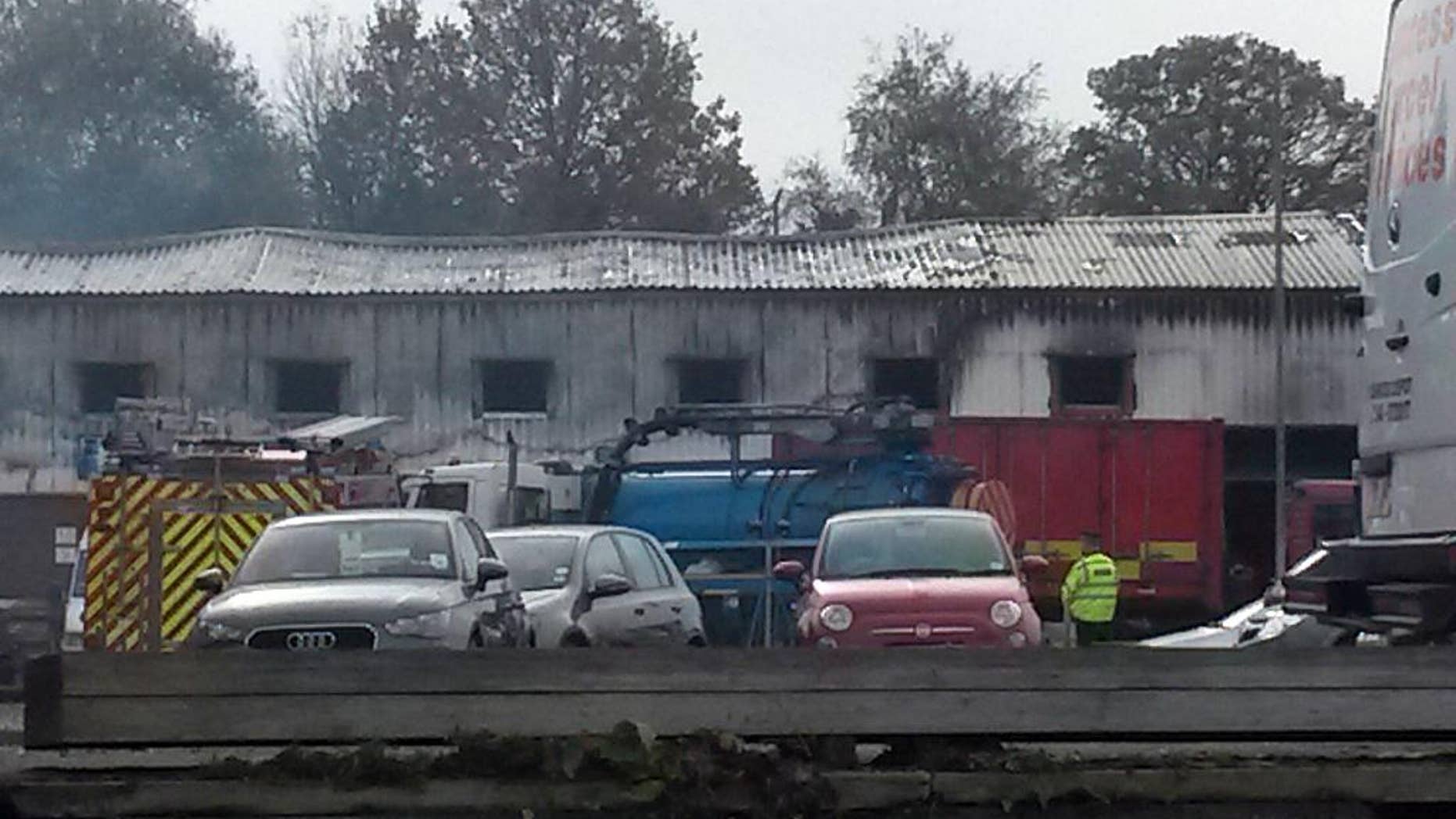 Smoke still drifts from the scene as emergency services damp down the area, after a fireworks factory went up in smoke early Friday, in Stafford, England, Friday Oct. 31, 2014, as rescue workers wait to search for two missing people. Two people are reported missing and a man has been arrested after the pyrotechnic blaze at a Stafford fireworks warehouse that left two people in hospital. (AP Photo / Richard Vernalls, PA) UNITED KINGDOM OUT - NO SALES - NO ARCHIVES