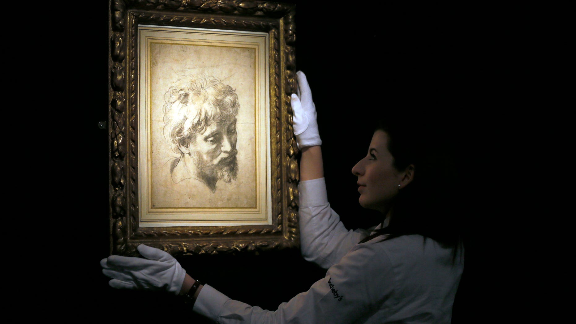 Nov. 30, 2012: A Sotheby's employee adjusts a drawing by Raffaello Sanzio, otherwise known as Raphael called 'Head of an Apostle', a Renaissance masterwork, during a press viewing in London.