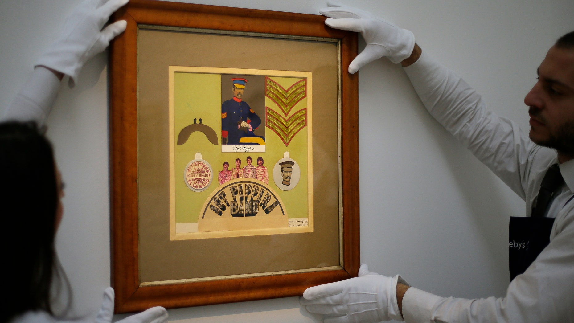 Nov. 9, 2012: Employees from Sotheby's auction house adjust the original Sir Peter Blake 1967 collage for the iconic Beatles album Sgt Pepper's Lonely Hearts Club Band, which will be sold at auction, during a press viewing in London.