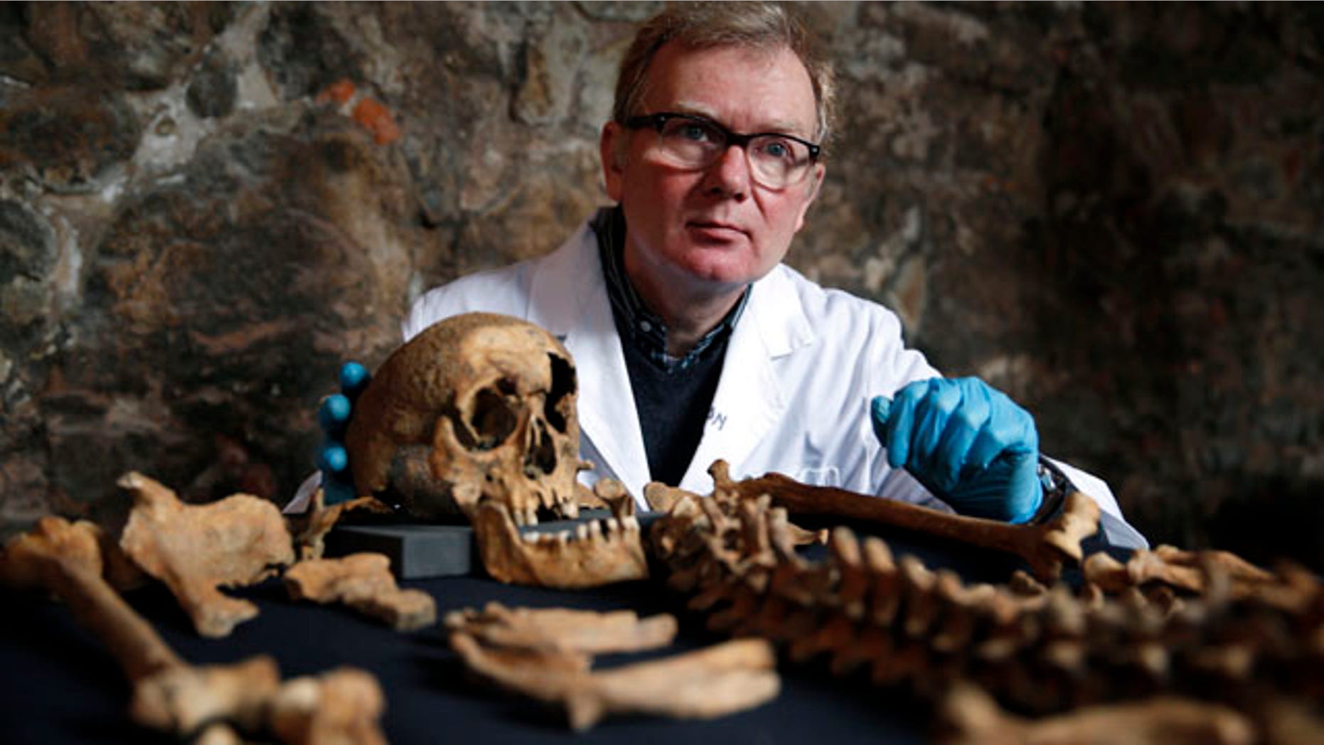 March 26, 2014: Don Walker, a human osteologist with the Museum of London, poses for photographers, with one of the skeletons found by construction workers under central London's Charterhouse Square. Twenty-five skeletons were uncovered last year during work on Crossrail, a new rail line that's boring 13 miles of tunnels under the heart of the city. Archaeologists immediately suspected the bones came from a cemetery for victims of the bubonic plague that ravaged Europe in the 14th century. The Black Death, as the plague was called, is thought to have killed at least 75 million people, including more than half of Britain's population. (AP Photo/Lefteris Pitarakis)