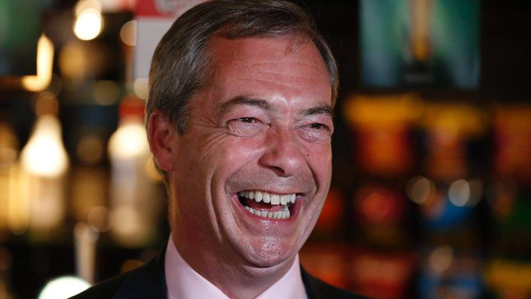 FILE - In this Friday, May 23, 2014 file photo, Nigel Farage, leader of Britain's United Kingdom Independence Party (UKIP) smiles at a pub in South Benfleet, England. British politician Nigel Farage has defended a hotel that insisted a breast-feeding mother cover up, suggesting women might "sit in the corner" while they feed their babies. Farage told LBC radio Friday Dec. 5, 2014 that women should breast-feed "in a way that is not openly ostentatious." (AP Photo/Lefteris Pitarakis, File)