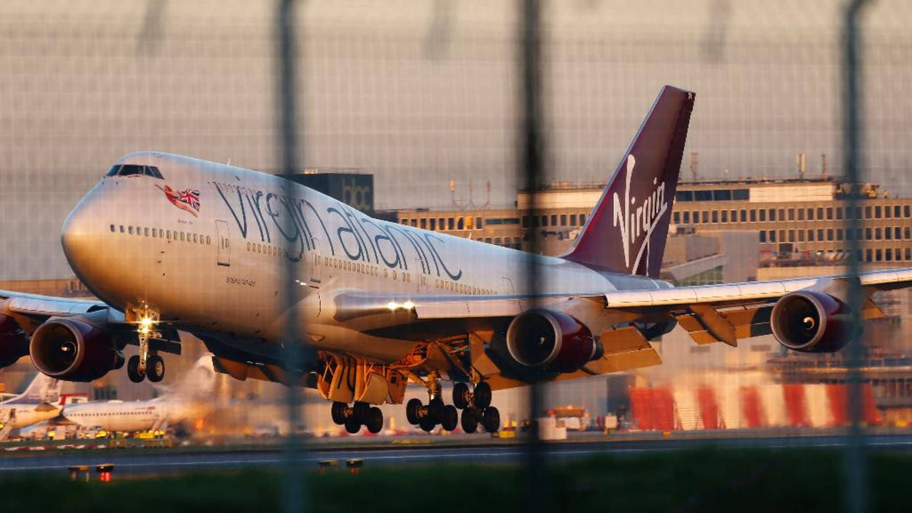 A Virgin Atlantic Boeing passenger jet performs an emergency landing at Gatwick Airport after developing a landing gear fault, London, Monday, Dec. 29 2014. The airline says the plane undertook "a non-standard landing procedure" because of "a technical issue with one of the landing gears." (AP Photo/PA, Gareth Fuller) UNITED KINGDOM OUT, NO SALES, NO ARCHIVE