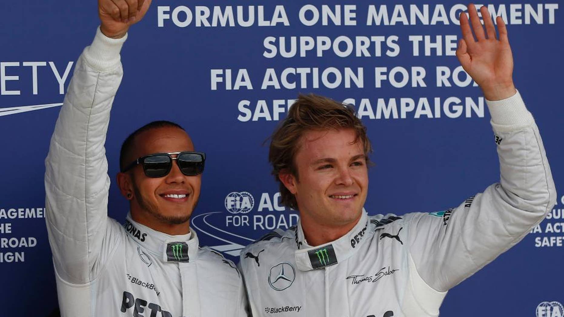FILE - In this Saturday, June 29, 2013, file photo, Mercedes driver Lewis Hamilton of Great Britain, left, celebrates after winning the pole position, along with his teammate Nico Rosberg, right, of Germany who finished second following the qualifying session at the Silverstone circuit, England. Mercedes' rivals hope a busy three weeks of tinkering on their slower cars and the move to European tracks will be enough to at least threaten Lewis Hamilton's and Nico Rosberg's stranglehold on Formula One. (AP Photo/Lefteris Pitarakis)