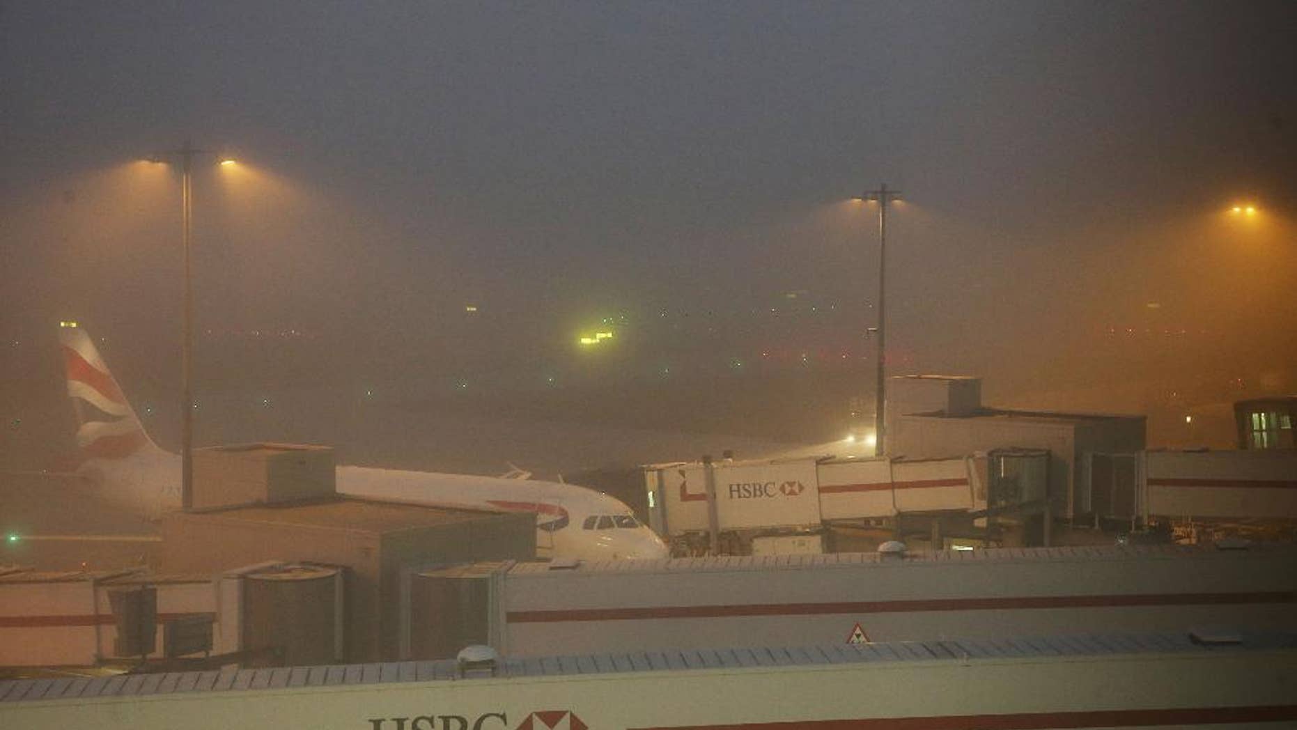 A British Airways plane stands on the ground at Heathrow Airport Terminal 5, as some dozens of flights have been canceled at the airport due to thick fog in the area, Sunday Nov. 1, 2015. A spokeswoman for Britain's busiest airport said the weather had forced the cancellation of about 50 flights and advised passengers caught up in the disruption to contact their airlines. (Steve Parsons / PA via AP) UNITED KINGDOM OUT - NO SALES - NO ARCHIVES