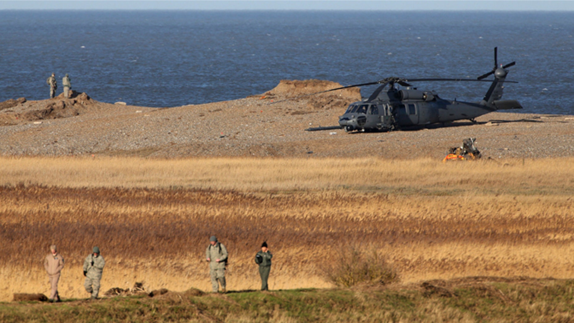 Jan. 8, 2014: The wreckage of a US Military Air Force Pave Hawk helicopter, partially obscured in front of helicopter right, lies on the ground in Salthouse, England, after the helicopter crashed late Tuesday killing all four crew members aboard.