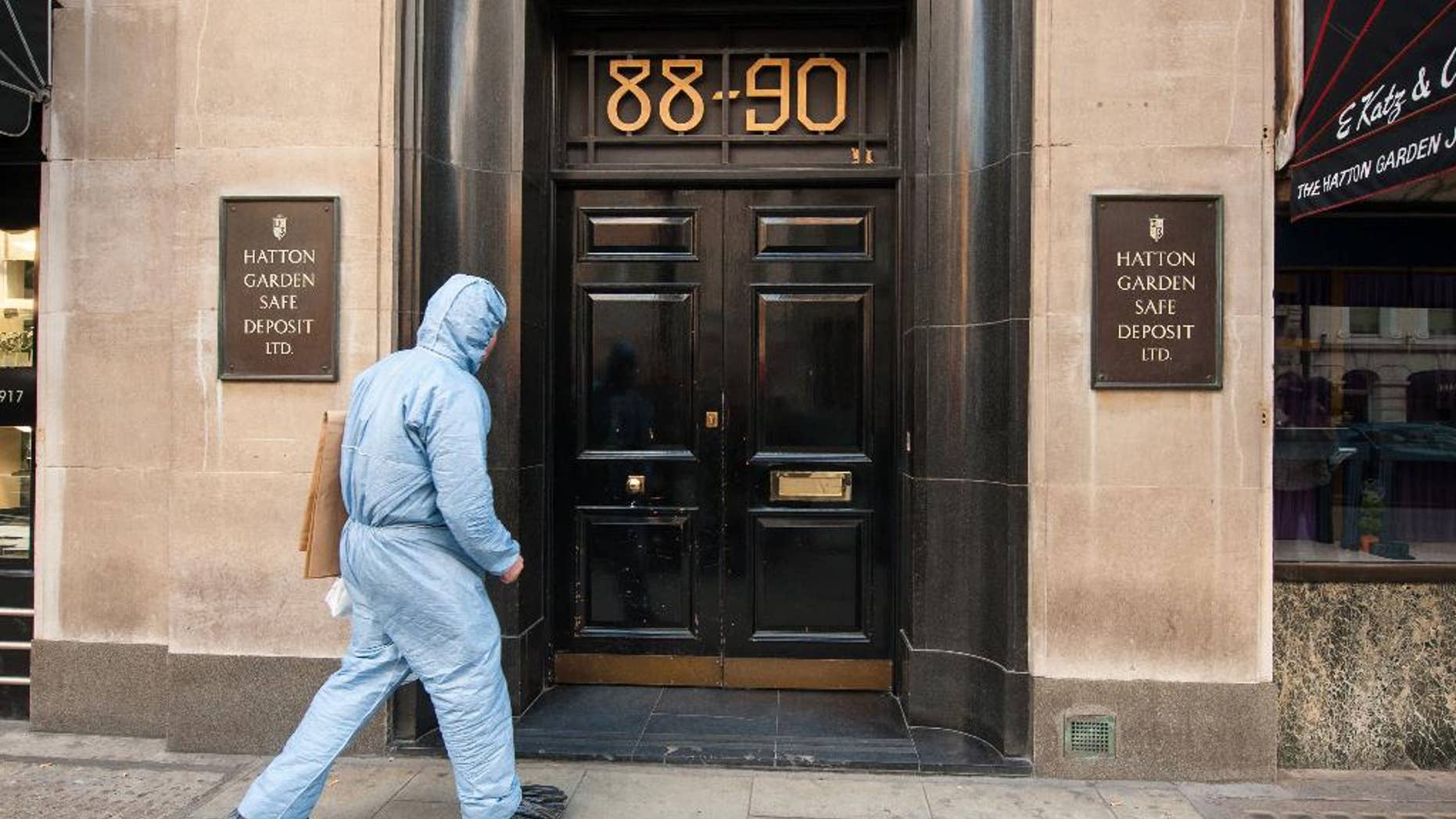 FILE - In this Tuesday, April 7, 2015 file photo, Police forensics officer enter the Hatton Garden Safe Deposit company in London. More than 200 British police swooped down on suspected jewel thieves Tuesday, May 19, 2015, making arrests in the notorious Hatton Garden heist that took place in London over the Easter weekend. Scotland Yard said seven British men, ranging in age from 48 to 76, are being questioned in a London police station after the morning raids. The men were arrested in north London and in Kent, southeast of the city. (Dominic Lipinski/PA via AP, file) UNITED KINGDOM OUT - NO SALES - NO ARCHIVES
