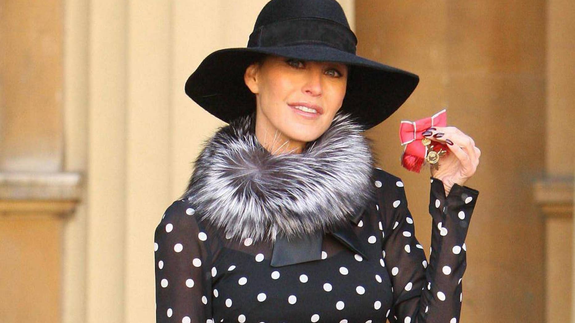 FILE- In this Wednesday Oct. 20, 2010 file photo, Britain's Tamara Mellon, co-founder of Jimmy Choo, displays her OBE, which was awarded by Britain's Queen Elizabeth II, at an investiture ceremony at Buckingham Palace, London. Luxury shoemaker Jimmy Choo has announced plans to list at least a quarter of its shares on the London Stock Exchange next month in Oct. 2014. The designer label, which recorded sales of 282 million pounds ($462 million) in 2013, said it is looking to expand in Asia and other new markets, and plans to open 10 to 15 stores per year. Malaysian-born designer Jimmy Choo and the brand's co-founder Tamara Mellon opened their first store in London in 1996. It is now owned by private investment firm JAB Luxury, which acquired it in 2011, and the label now has 120 stores worldwide. Peter Harf, non-executive chairman of Jimmy Choo, said in a statement Tuesday the company is "confident that shareholders can expect strong growth and cash flow in the years to come." (AP Photo/Dominic Lipinski, Pool, file)