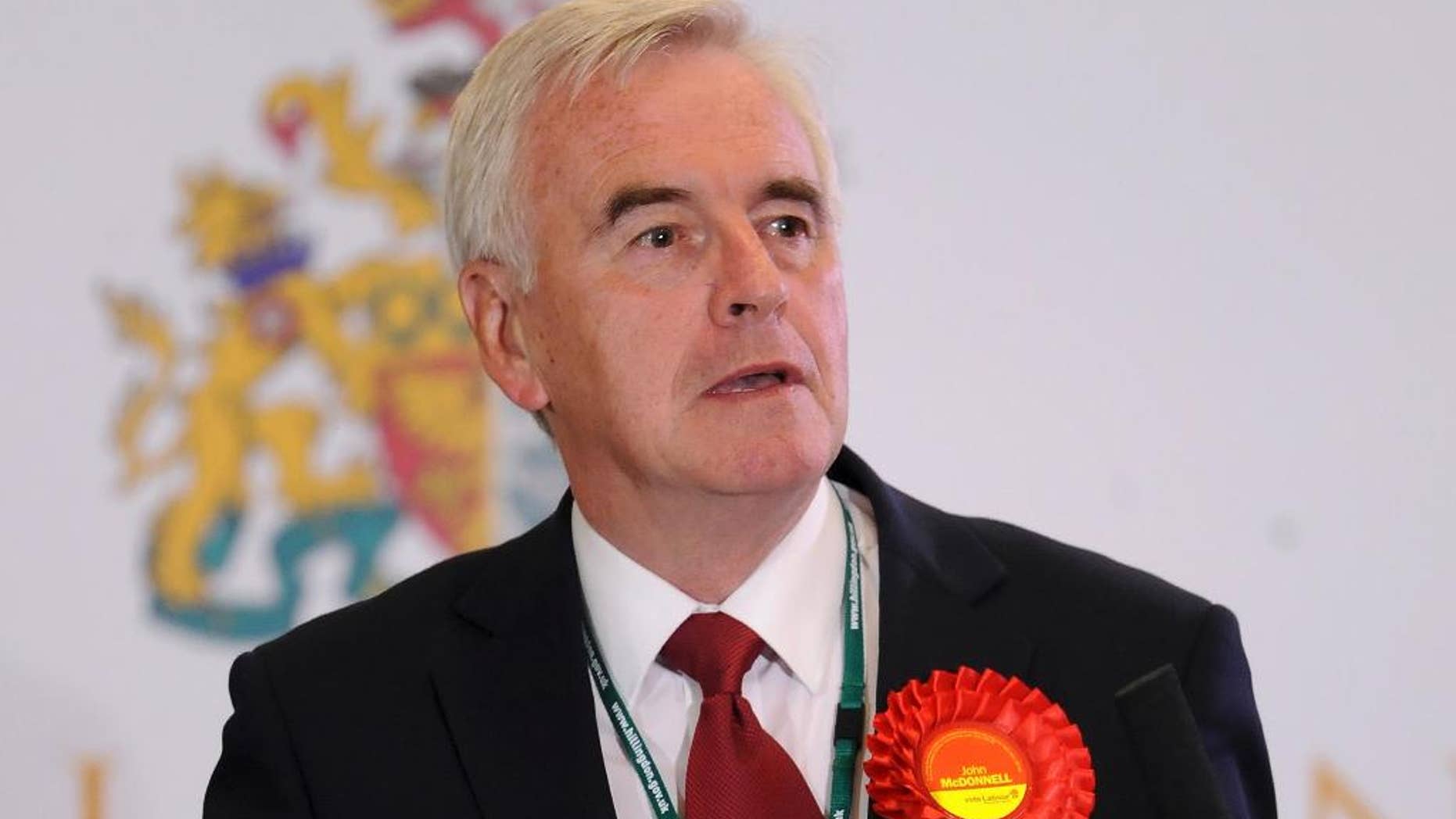 FILE - In this May 8, 2015 file photo MP John McDonnell speaks during a meeting in London. A top official in Britain's Labour Party has apologized for saying Irish Republican Army bombings and shootings helped bring about peace in Northern Ireland. John McDonnell, a veteran left-wing lawmaker, was appointed Labour's Treasury spokesman this week by new party leader Jeremy Corbyn. (Andrew Matthews/PA File via AP) UNITED KINGDOM OUT