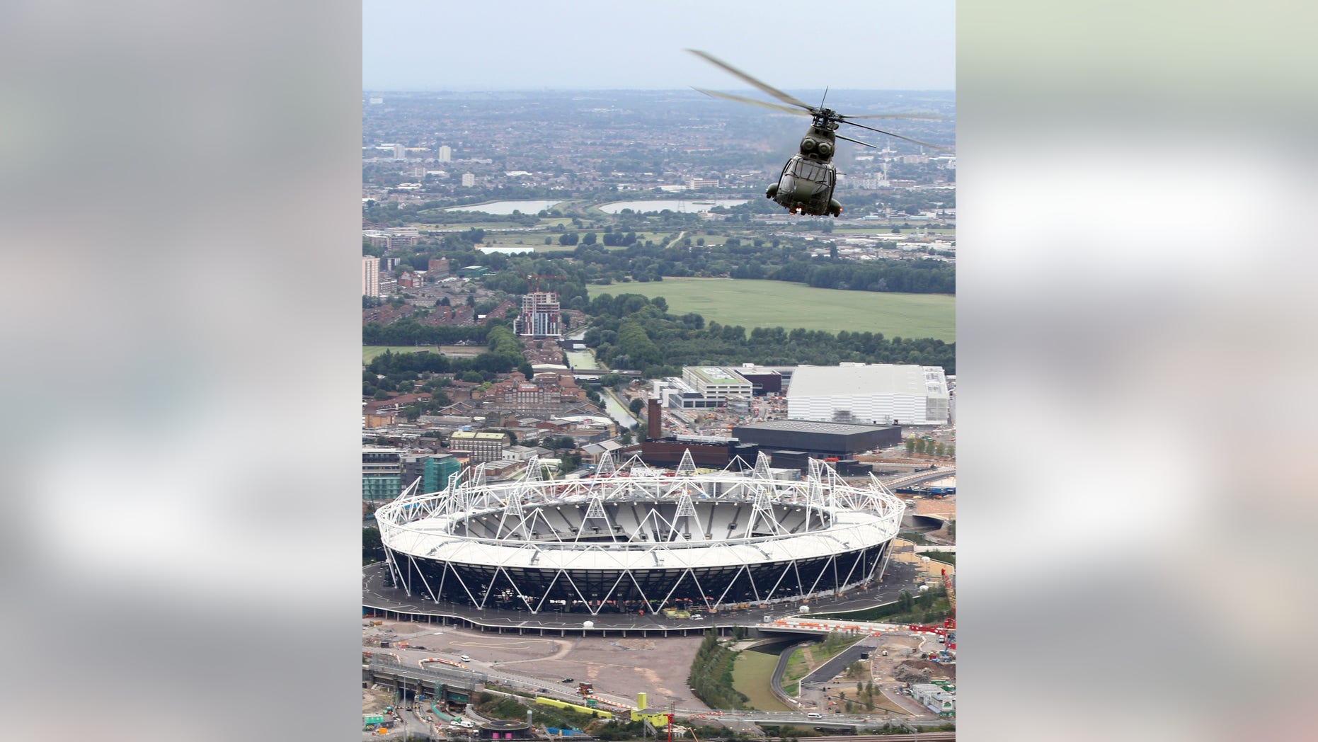 FILE - This is a Aug. 18, 2011 file photo released by Britain's Ministry of Defence shows Royal Air Force Puma helicopter is pictured flying over the 2012 Olympic Stadium during a training flight over London . Fighter jets thunder above the English countryside. Missiles stand ready. And Big Brother is watching like never before. The London Olympics are no ordinary games _ and Britain is no ordinary host. Not since World War II have Britain and the United States teamed up for such a massive security operation on British soil, and not without reason. (AP Photo/SAC Phil Major RAF, MOD)