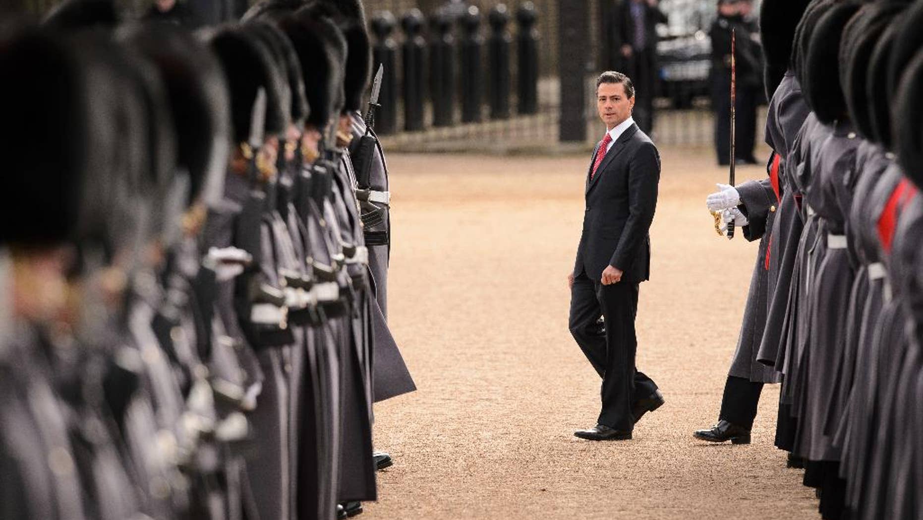 Mexican President Enrique Pena Nieto, centre, inspects a Guard of Honour during a ceremonial welcome in central London on Tuesday March 3, 2015. The President and his wife are on a 3 day state visit to Britain. (AP Photo/Loen Neal, Pool)