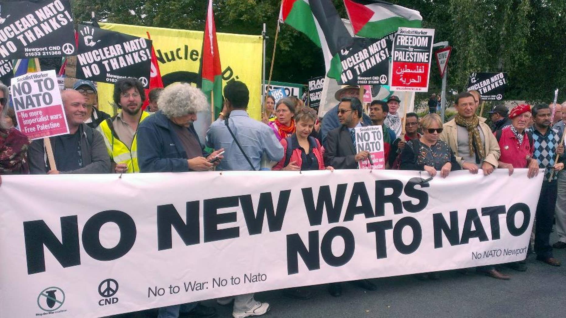 Supporters take part in the 'No to NATO' protest march in Newport, south Wales, Saturday, Aug. 30, 2014. Around 1,000 protesters have marched through the streets of Newport ahead of next week's NATO summit. More than 150 heads of state and ministers will attend the two-day event at Newport's Celtic Manor Resort. The event will be "uncharted territory" for police - while Wales' First Minister Carwyn Jones has said it will be "momentous" in his country's history. However, its presence in the principality - and the UK - has been met with strong opposition from a number of anti-war groups as well as left-wing organizations. A large crowd gathered outside Newport Crown Court at around midday before going on a march through the Welsh city. As well as strong Welsh contingent, protesters came from as far as Washington, Belgium, France and Ireland. (AP Photo/Benjamin Wright, PA Wire) UNITED KINGDOM OUT - NO SALES - NO ARCHIVES