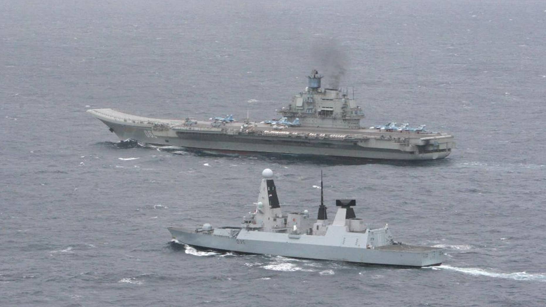An undated aerial photo made available by Britain's Ministry of Defence, Thursday, May 8, 2014 showing HMS Dragon, foreground, with the Russian aircraft carrier 'Admiral Kuznetsov' in the English Channel. The Royal Navy warship met and tracked a Russian task force group as it entered the English Channel in an operation that the Ministry of Defense repeatedly stressed was a routine matter. HMS Dragon, a Type 45 destroyer, monitored the movement of the seven-strong Russian group led by the aircraft carrier Admiral Kuznetsov. The navy says that once the ships spotted each other they “sailed close by as a standard ‘meet and greet.’ ’’ (AP Photo/Ministry of Defence)