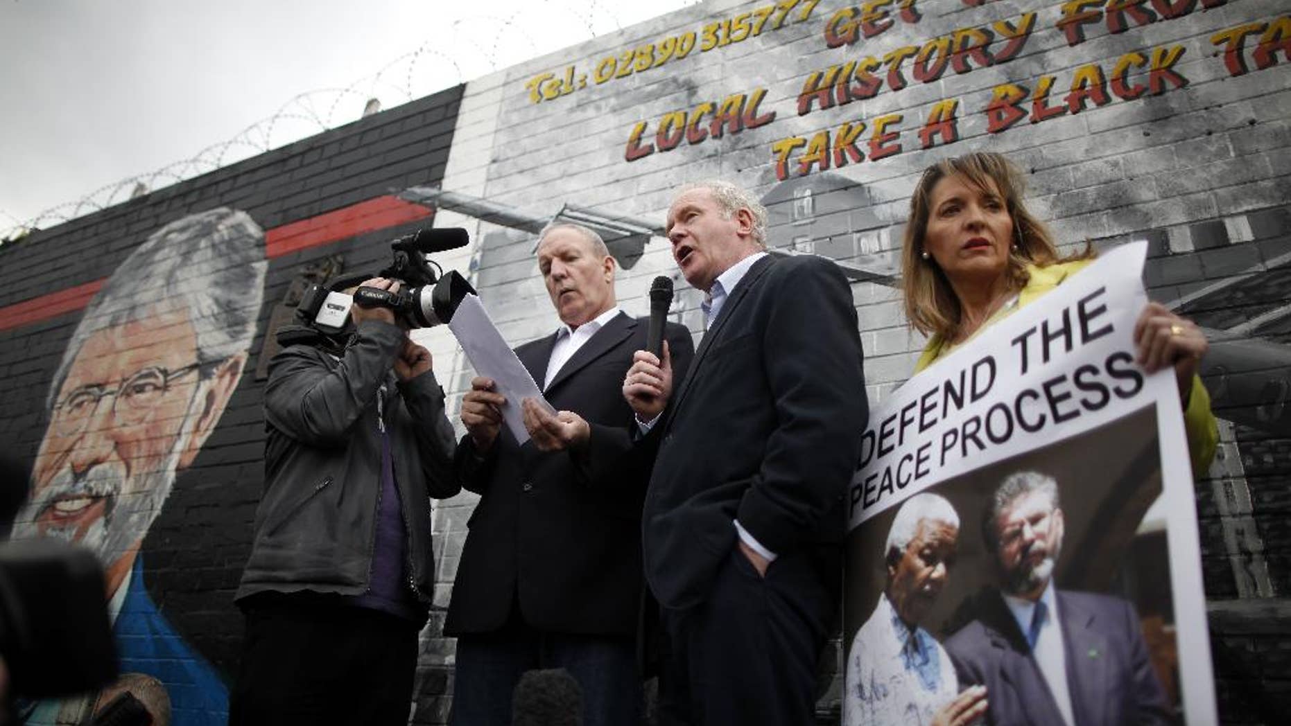 FILE - A Saturday, May 3, 2014 photo from files showing Sinn Fein's Martin McGuinness, centre, with party members Bobby Storey, left, and Martina Anderson speaking during a protest rally on the Falls Road, West Belfast, Northern Ireland. A prominent Irish Republican Army veteran has been arrested on suspicion of involvement in the IRA’s 1972 abduction, killing and secret burial of a widowed mother of 10, one of the outlawed group’s most notorious slayings. The Irish nationalist Sinn Fein party says its Northern Ireland chairman, Bobby Storey, was arrested Wednesday, Nov. 26, 2014. Police say he’s being interrogated about the killing of 38-year-old Jean McConville, whose remains were found bear an Irish beach in 2003. (AP Photo/Peter Morrison, File)