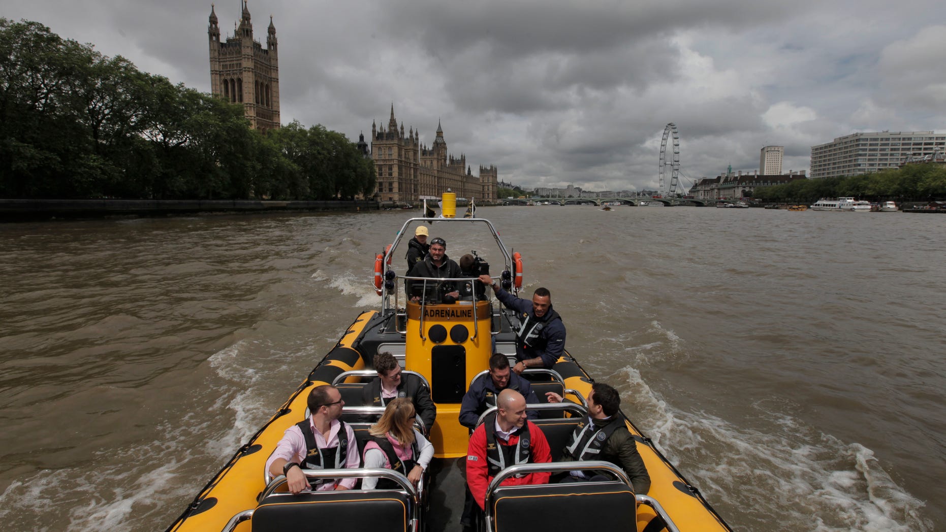 July 4, 2012: In this photo, people are seen aboard a high-speed 12-seater rigid inflatable boat, run by the Protection Services International company as it travels past the Palace of Westminster on London's river Thames.